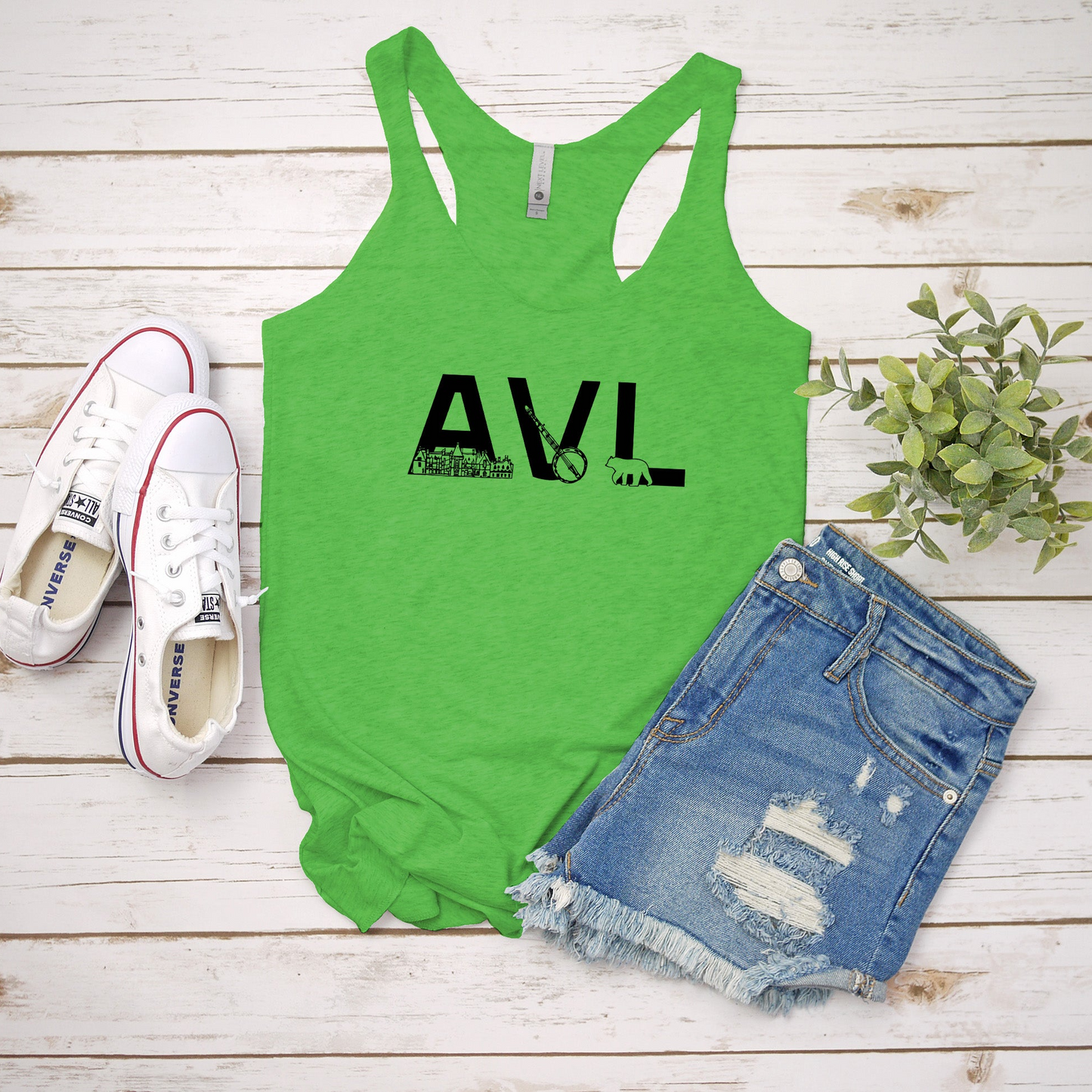 a green tank top with the word avl on it next to a pair of