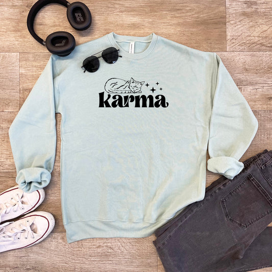 a sweater with the word karma on it next to headphones and a pair of