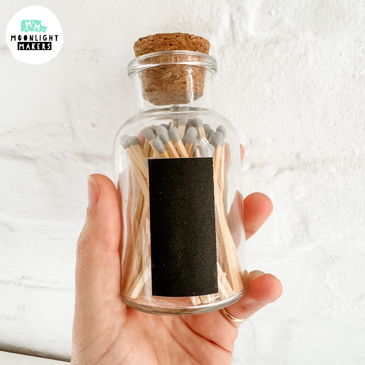 a person holding a glass jar filled with matches