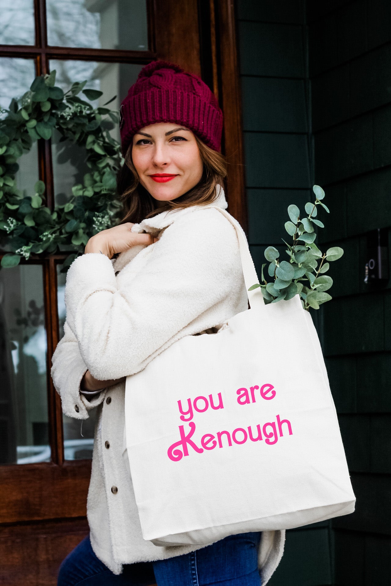 a woman holding a white bag that says you are kenouh