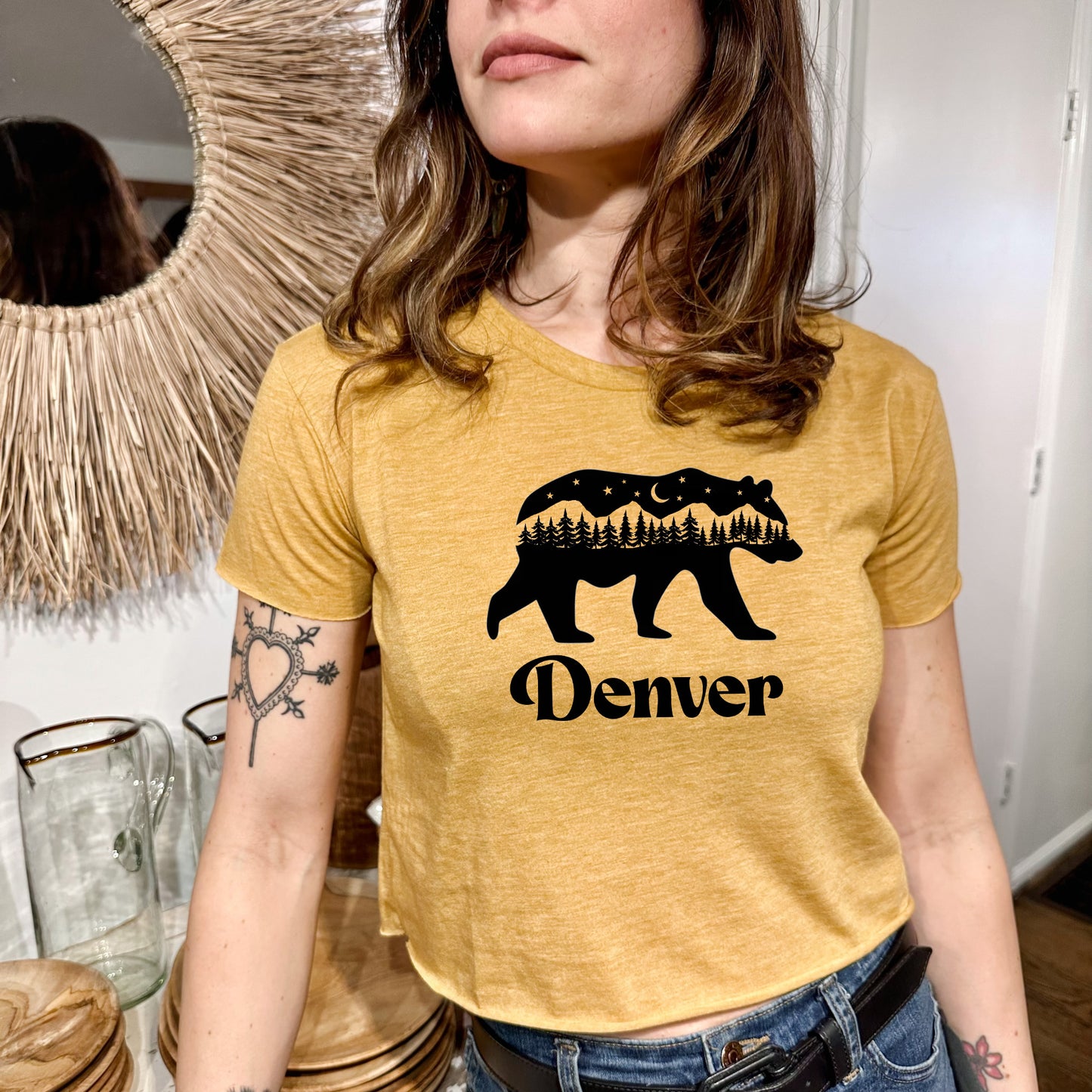 a woman standing in front of a mirror wearing a t - shirt with a bear