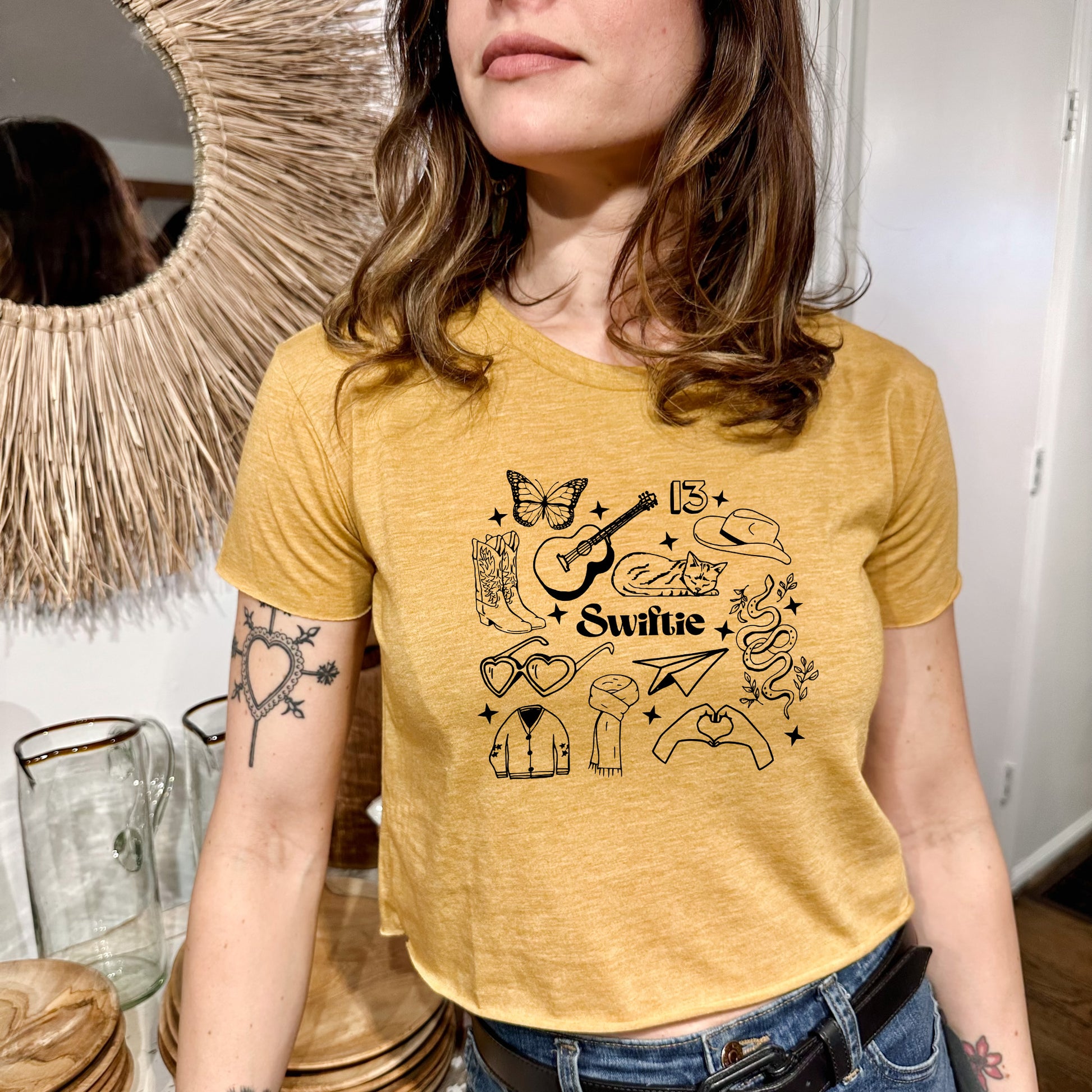 a woman wearing a yellow tshirt standing in front of a mirror