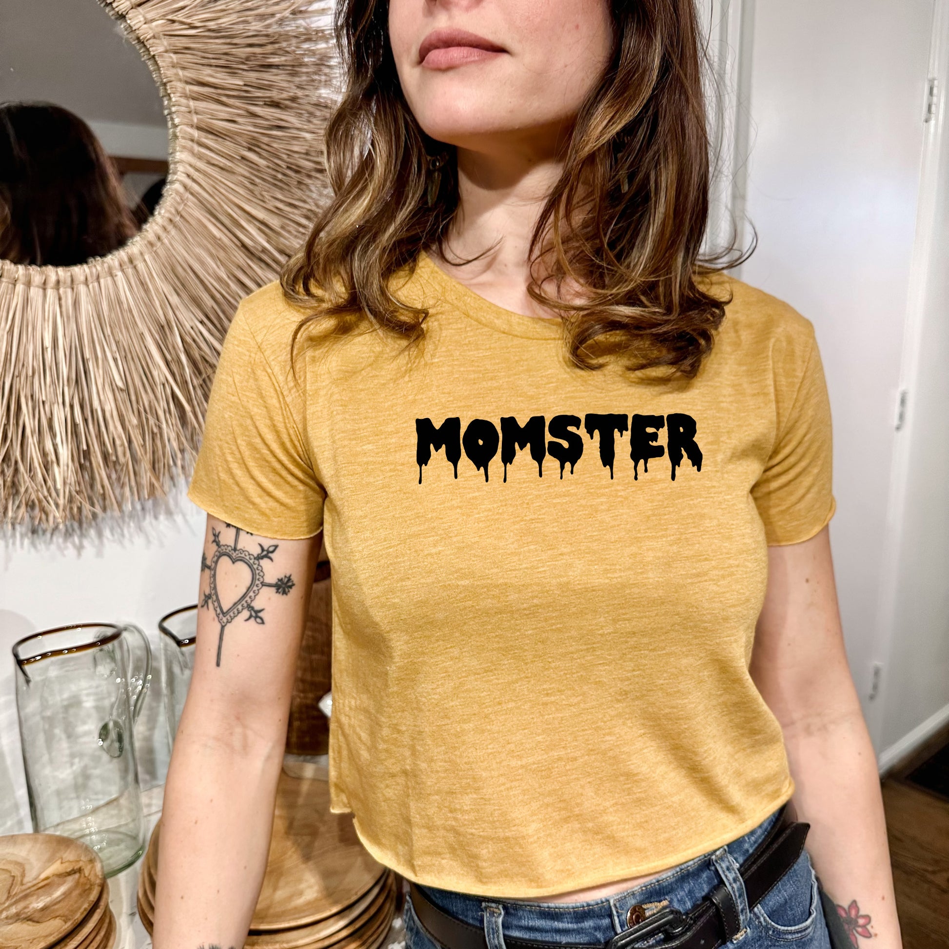 a woman wearing a yellow shirt with the word monster on it