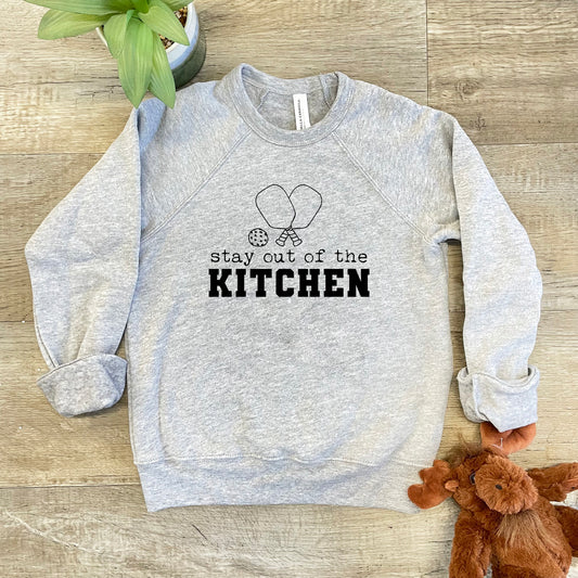 a gray sweatshirt that says stay out of the kitchen next to a teddy bear