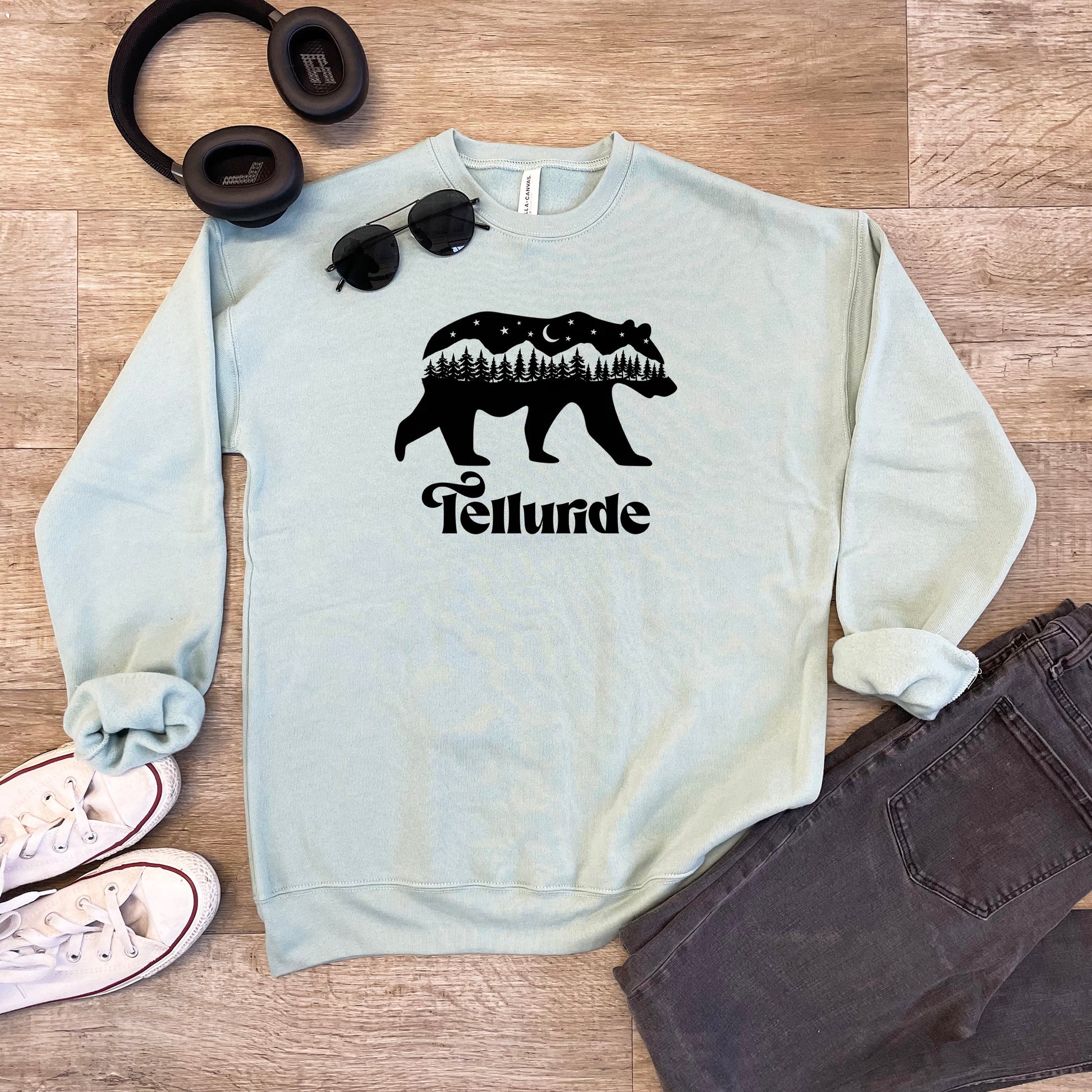 a sweater with a bear and trees on it