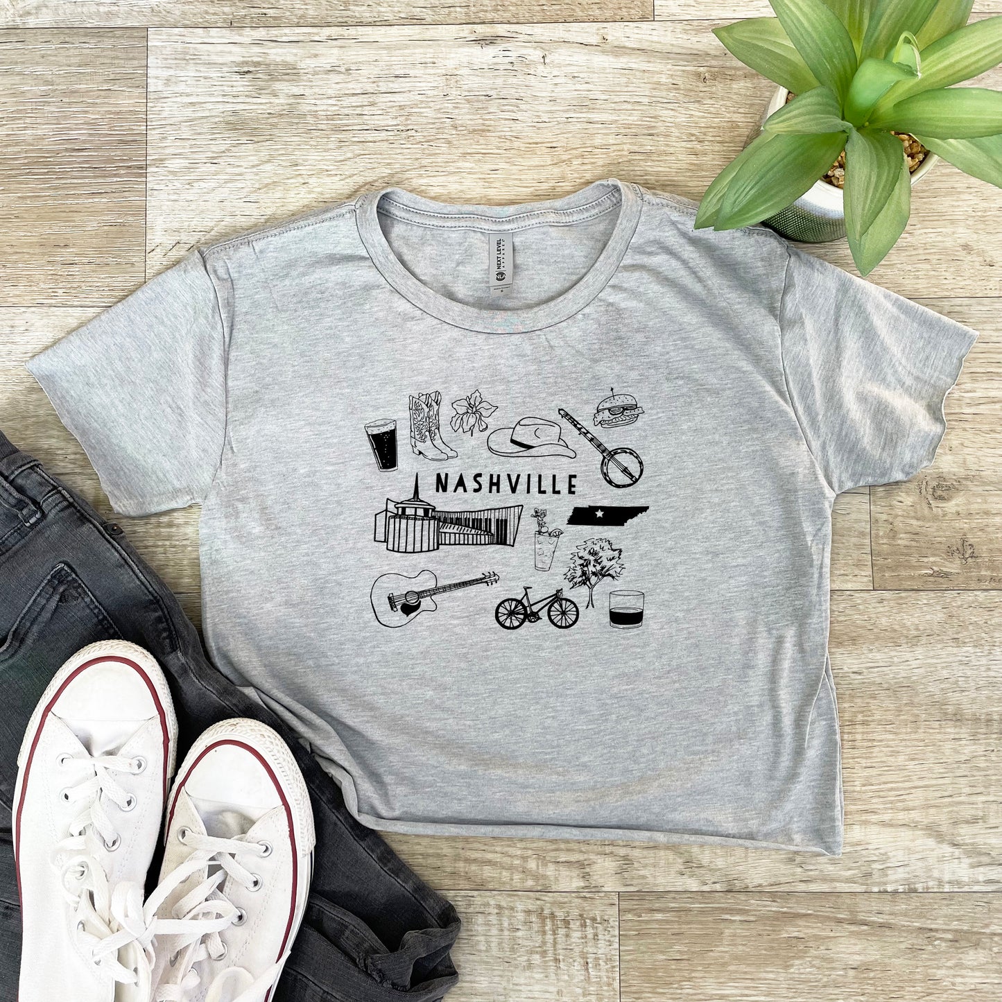 a t - shirt with the words nashville on it next to a pair of sneakers