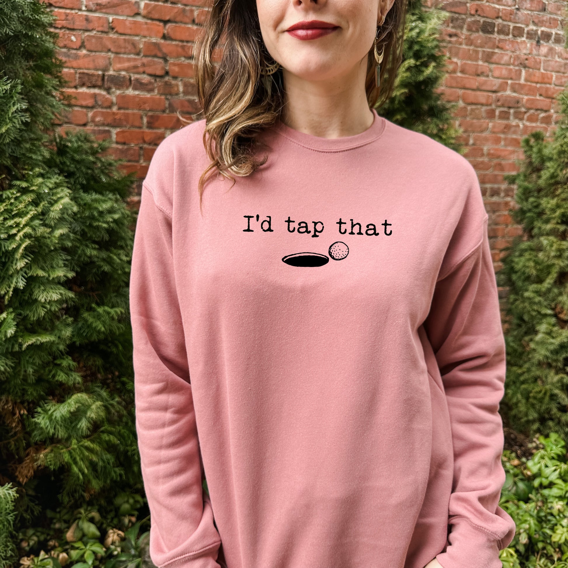 a woman wearing a pink sweatshirt that says i'd tap that