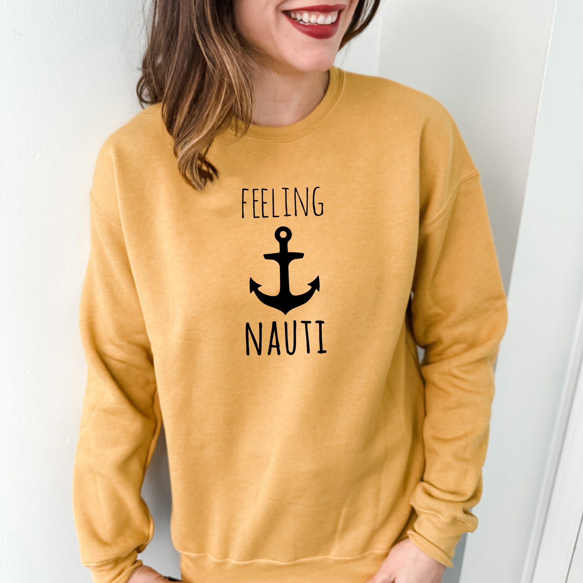 a woman wearing a yellow sweatshirt that says feeling nauti