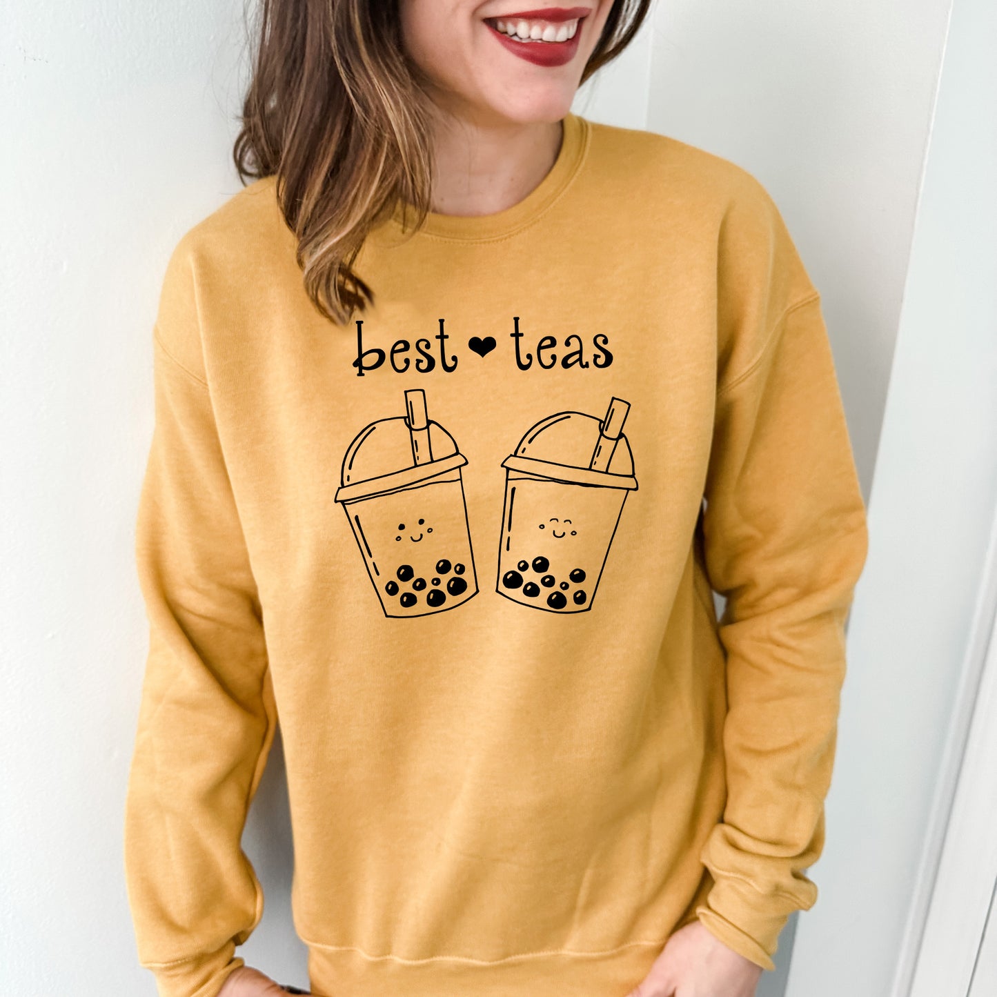 a woman wearing a sweatshirt that says best teas