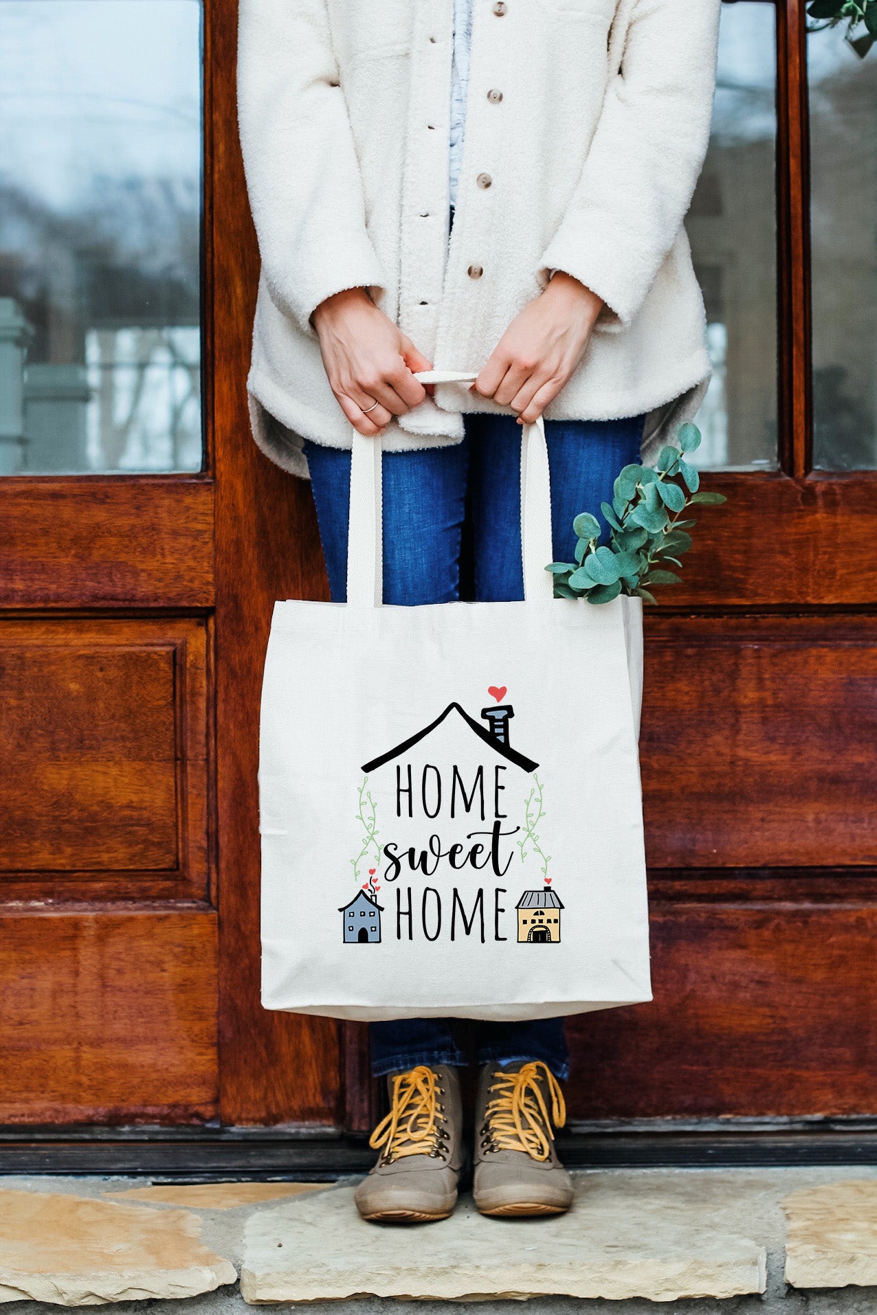 a woman holding a bag that says home sweet home