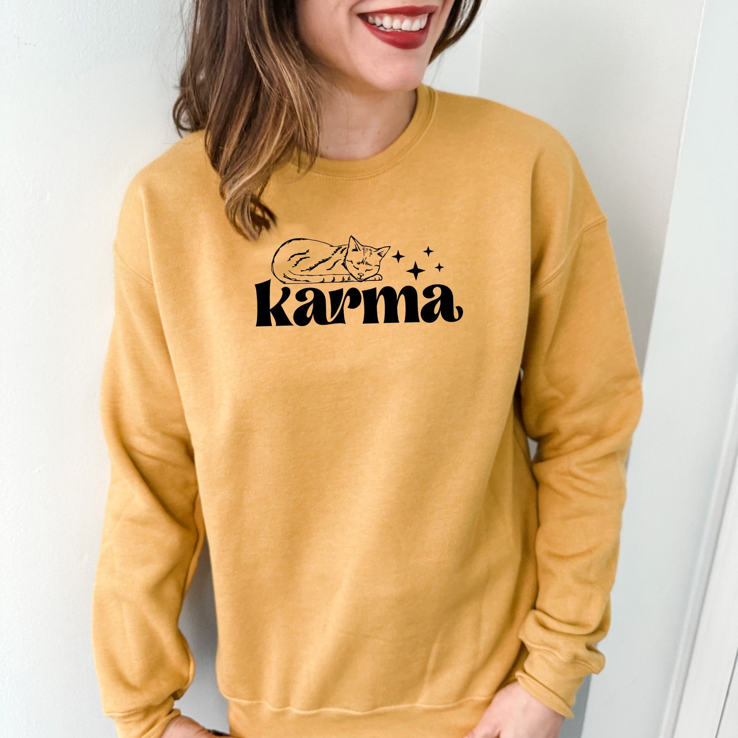 a woman wearing a yellow sweatshirt with the word karma printed on it