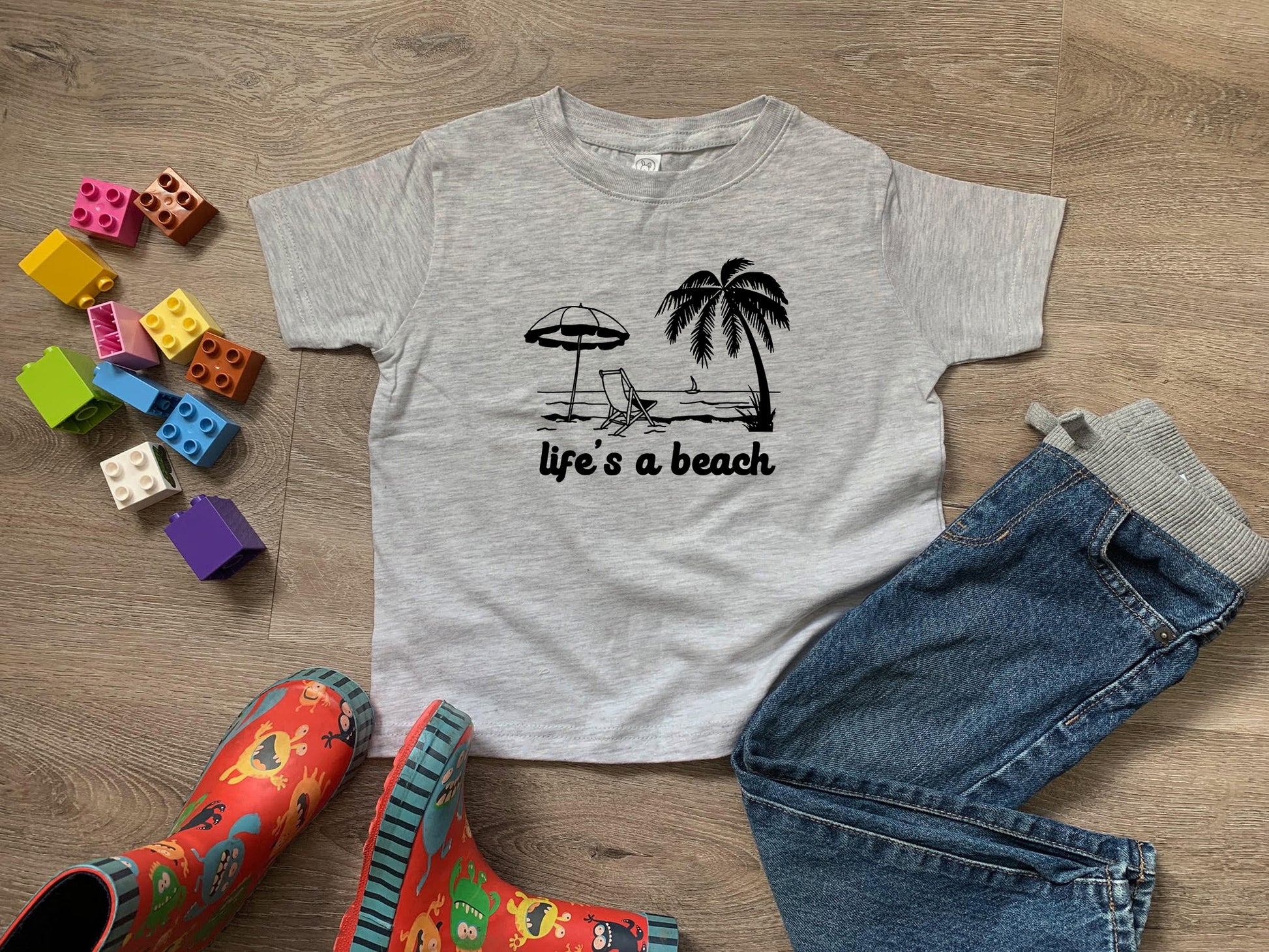 a t - shirt that says life's a beach next to a pair of