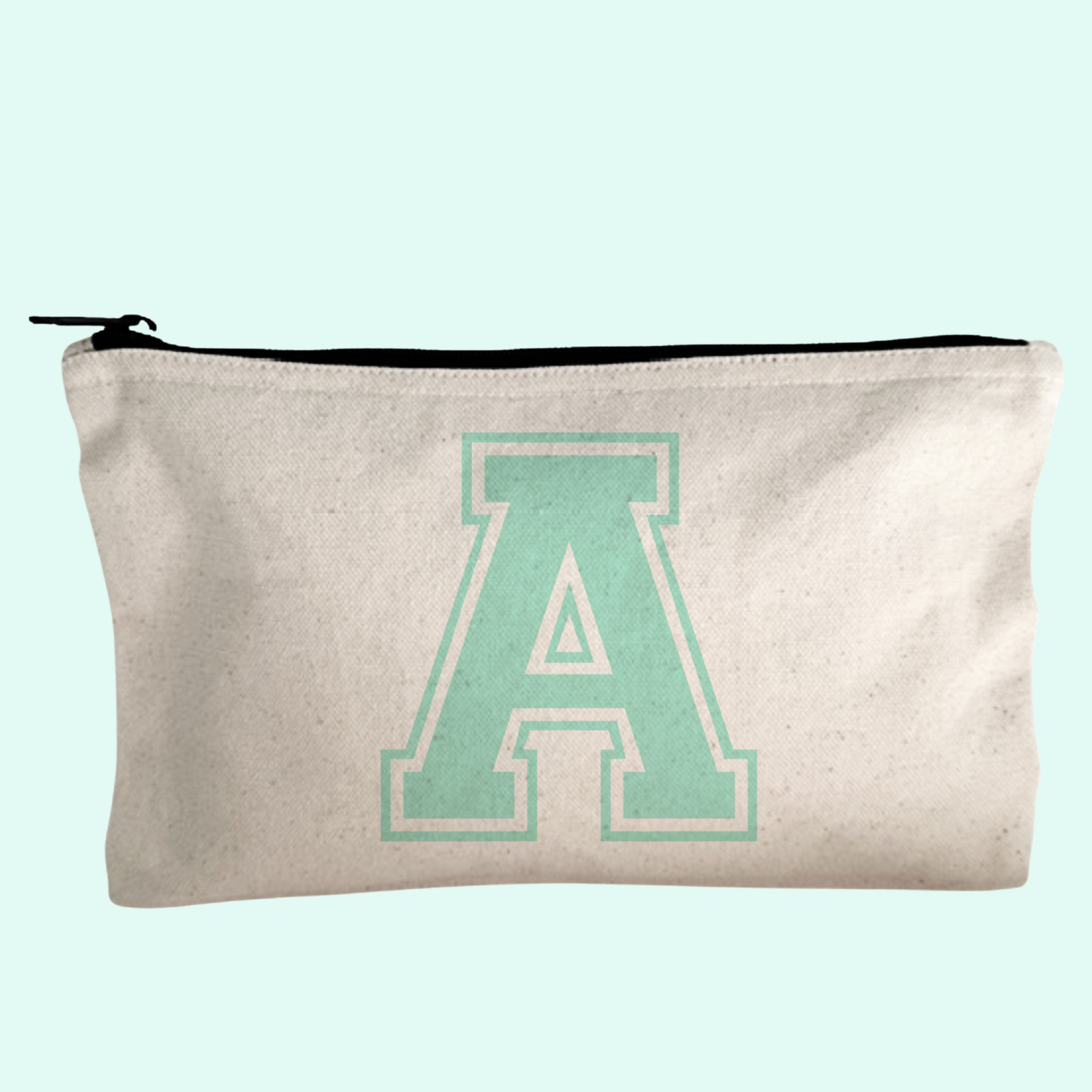 a green letter on a white canvas bag