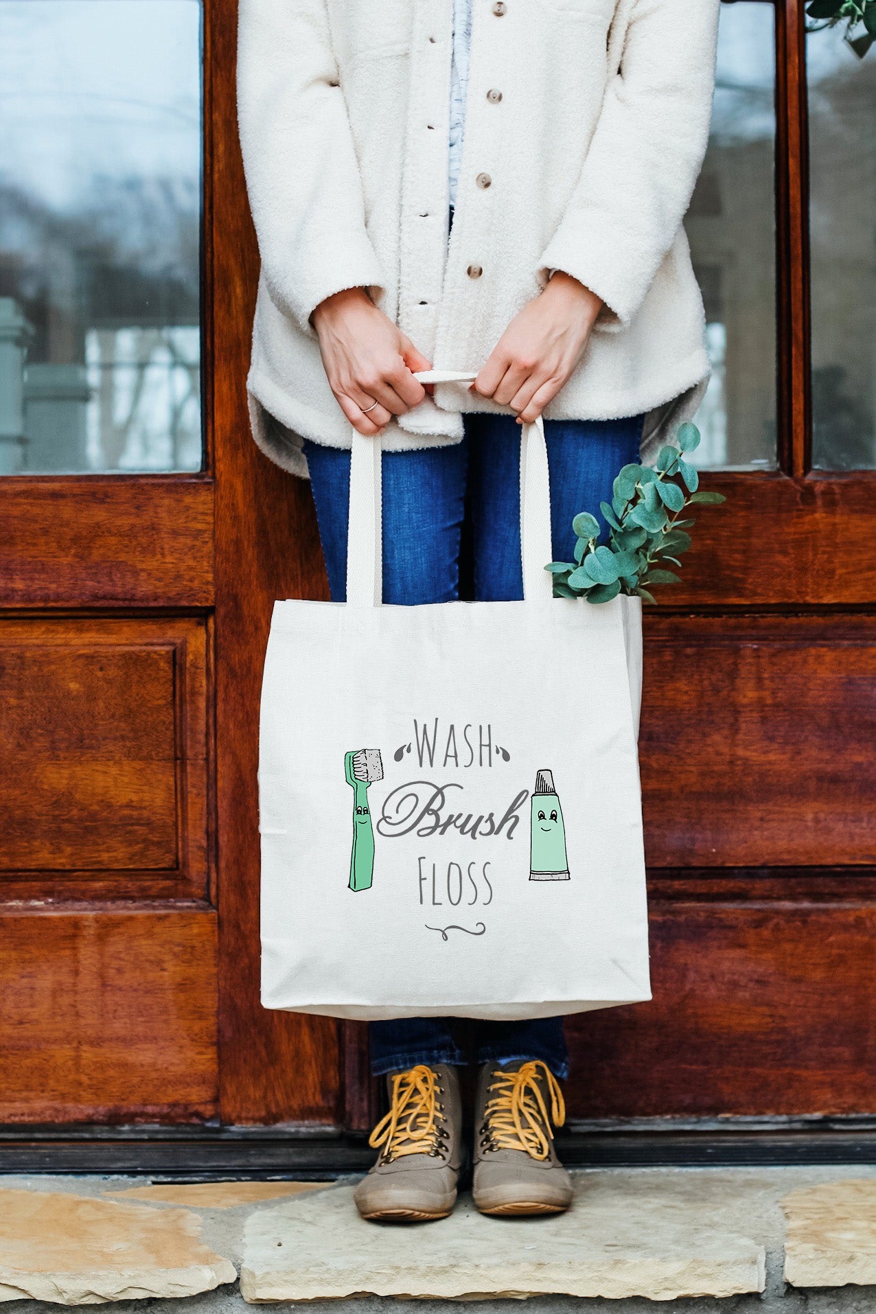 a woman holding a bag that says wash brush floss