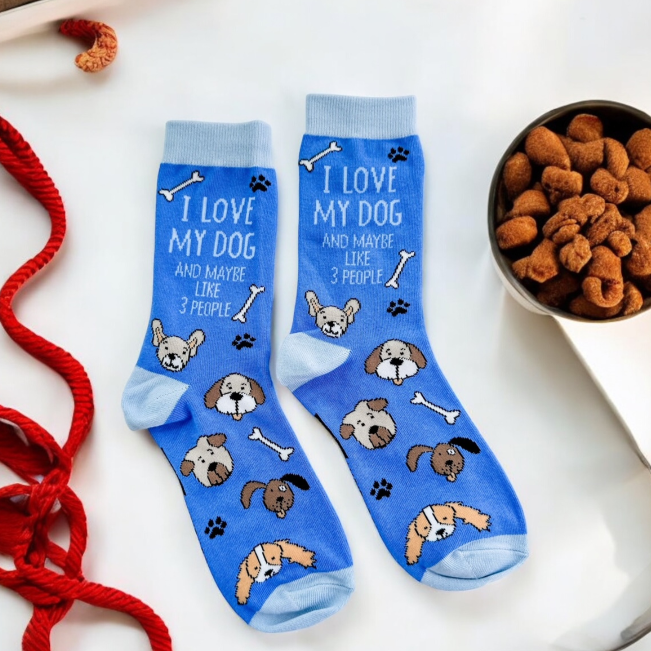 a pair of socks with dogs on them next to a bowl of dog treats