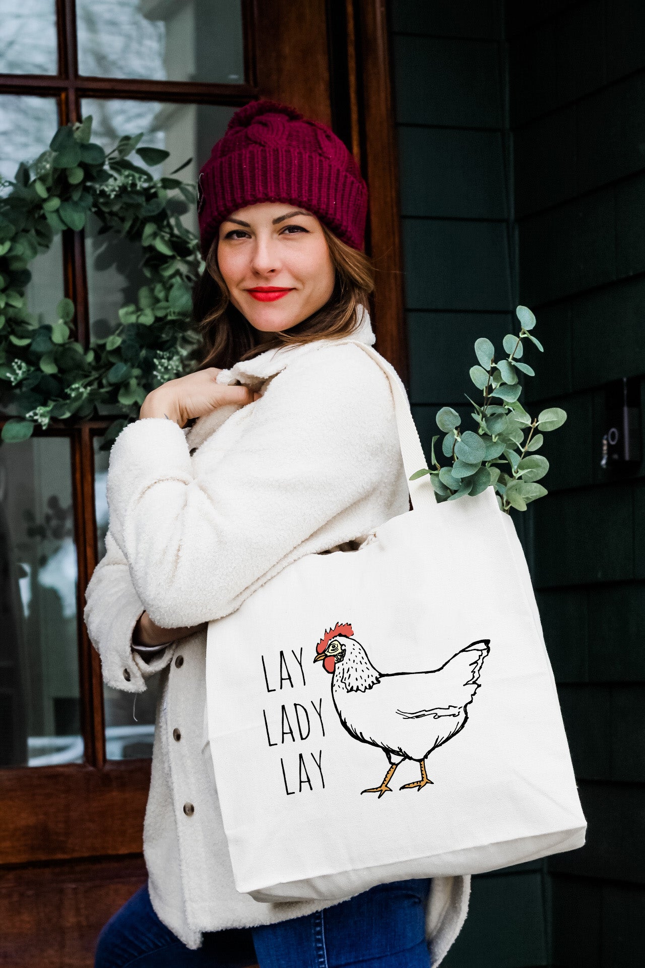 a woman carrying a bag with a chicken on it