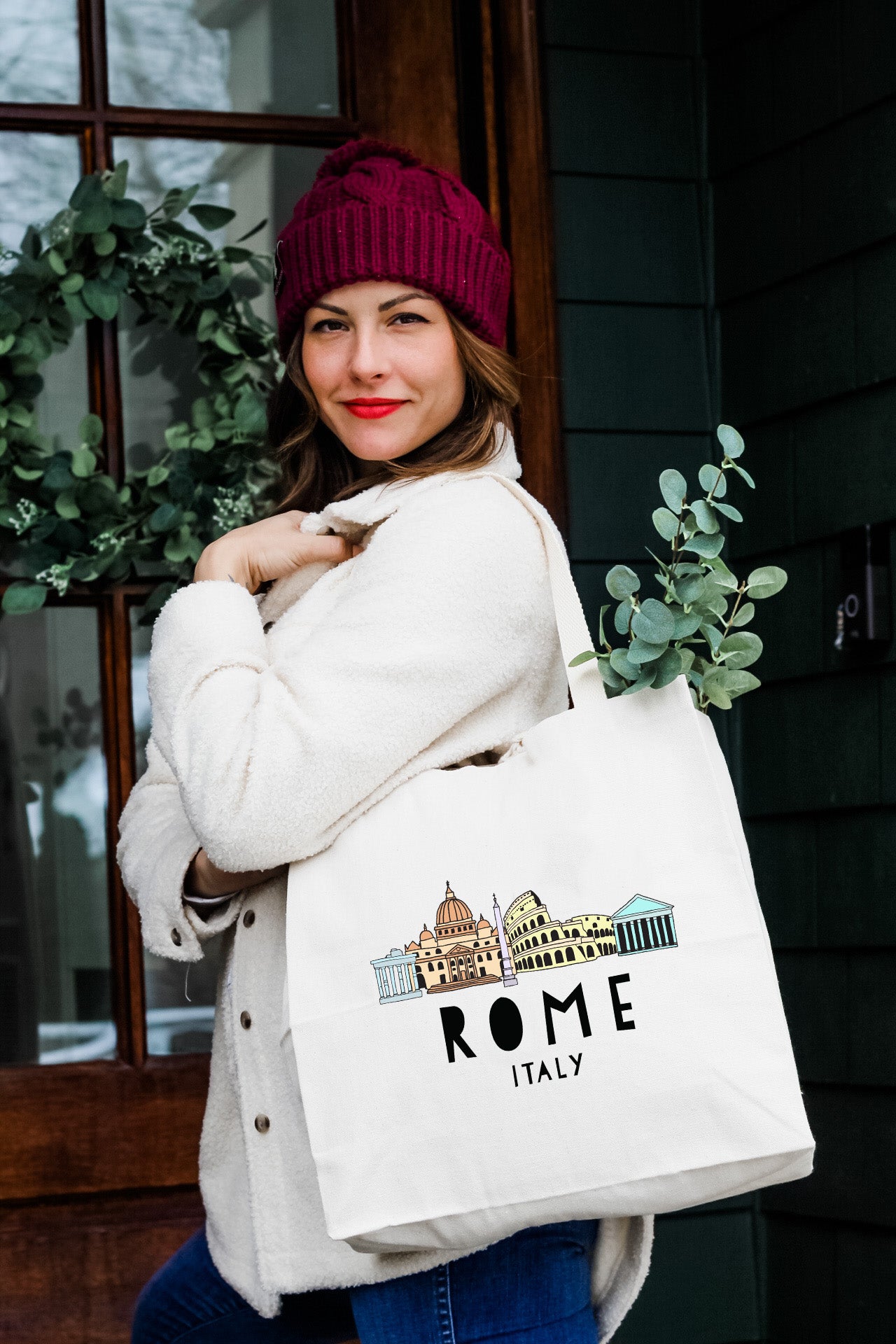 a woman carrying a white bag with a picture of a building on it