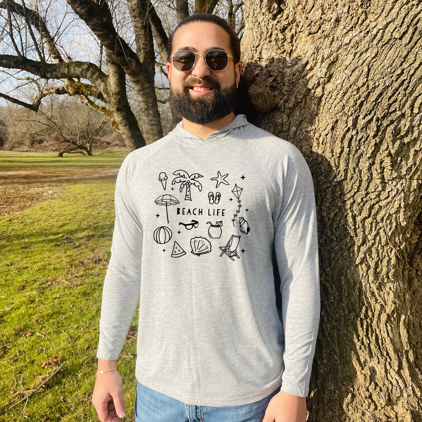 a man standing next to a tree in a park