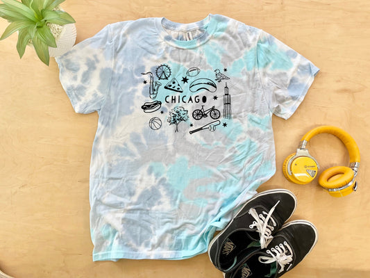 a t - shirt with chicago on it next to headphones and a pair of