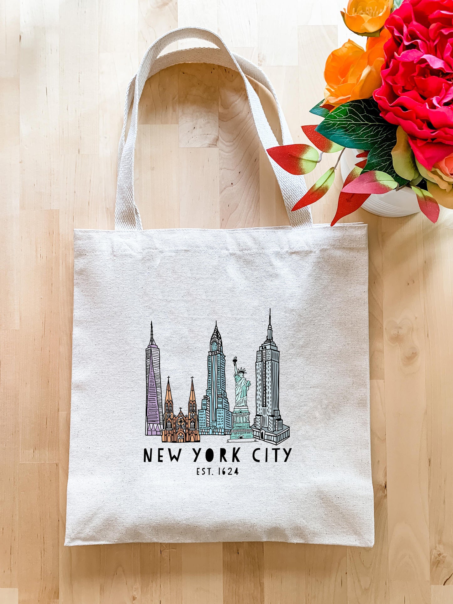 a new york city bag next to a bouquet of flowers