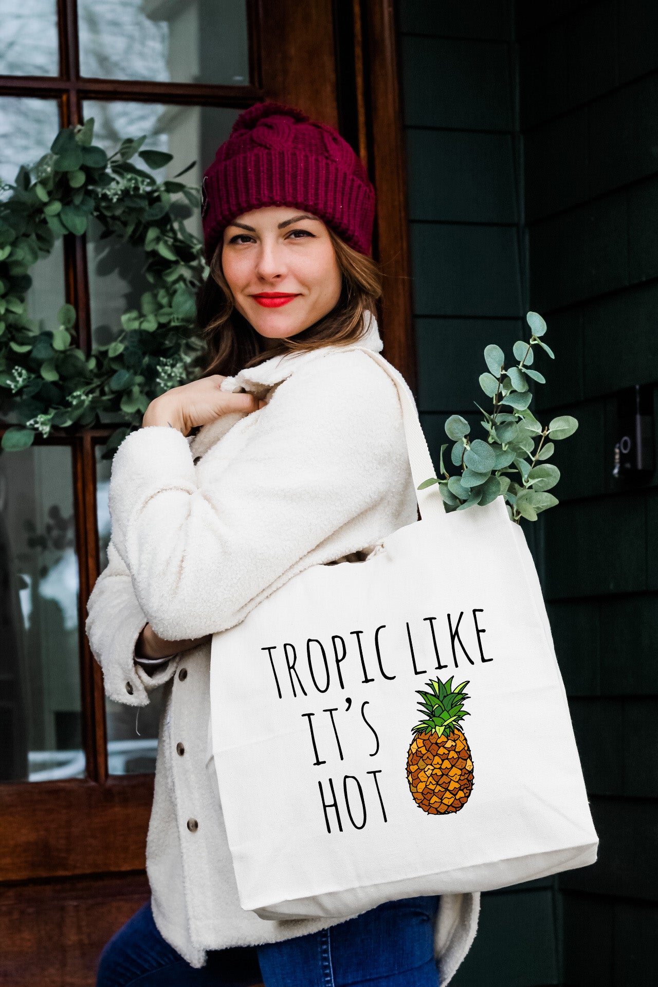 a woman carrying a bag that says tropical like it's hot