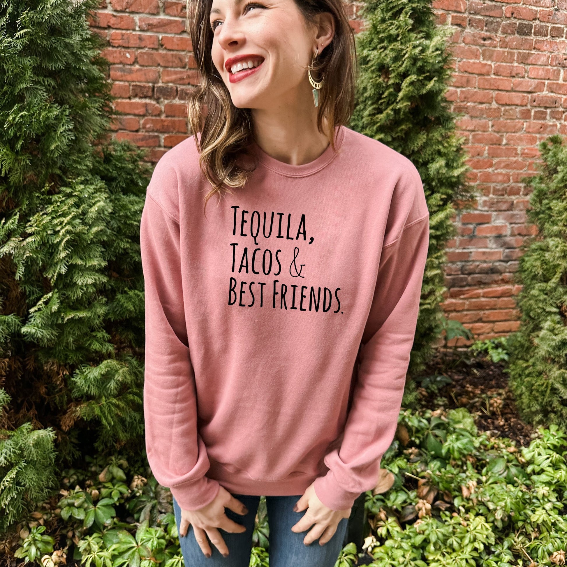 a woman standing in front of a brick wall