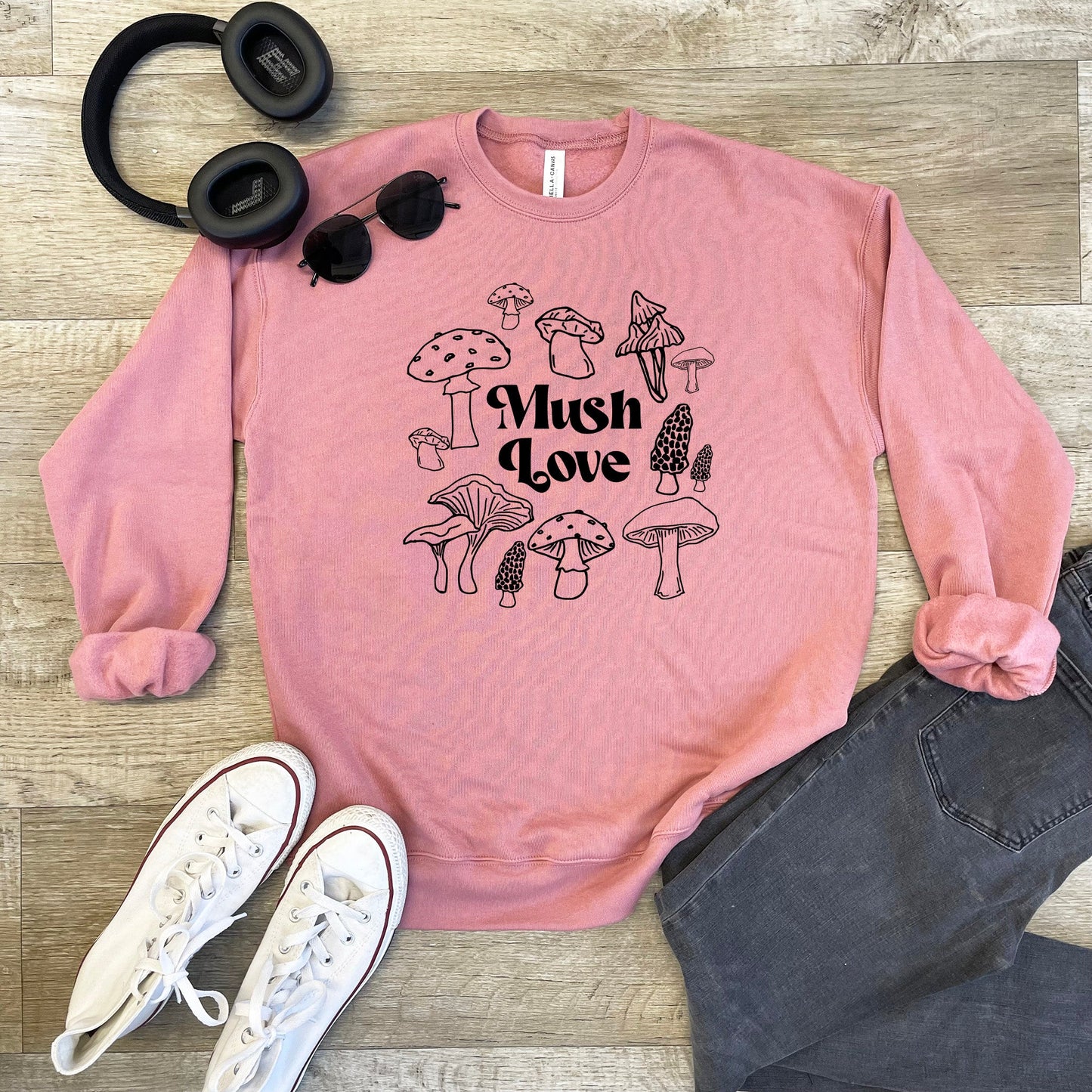 a pink sweatshirt with mushrooms on it and a pair of headphones