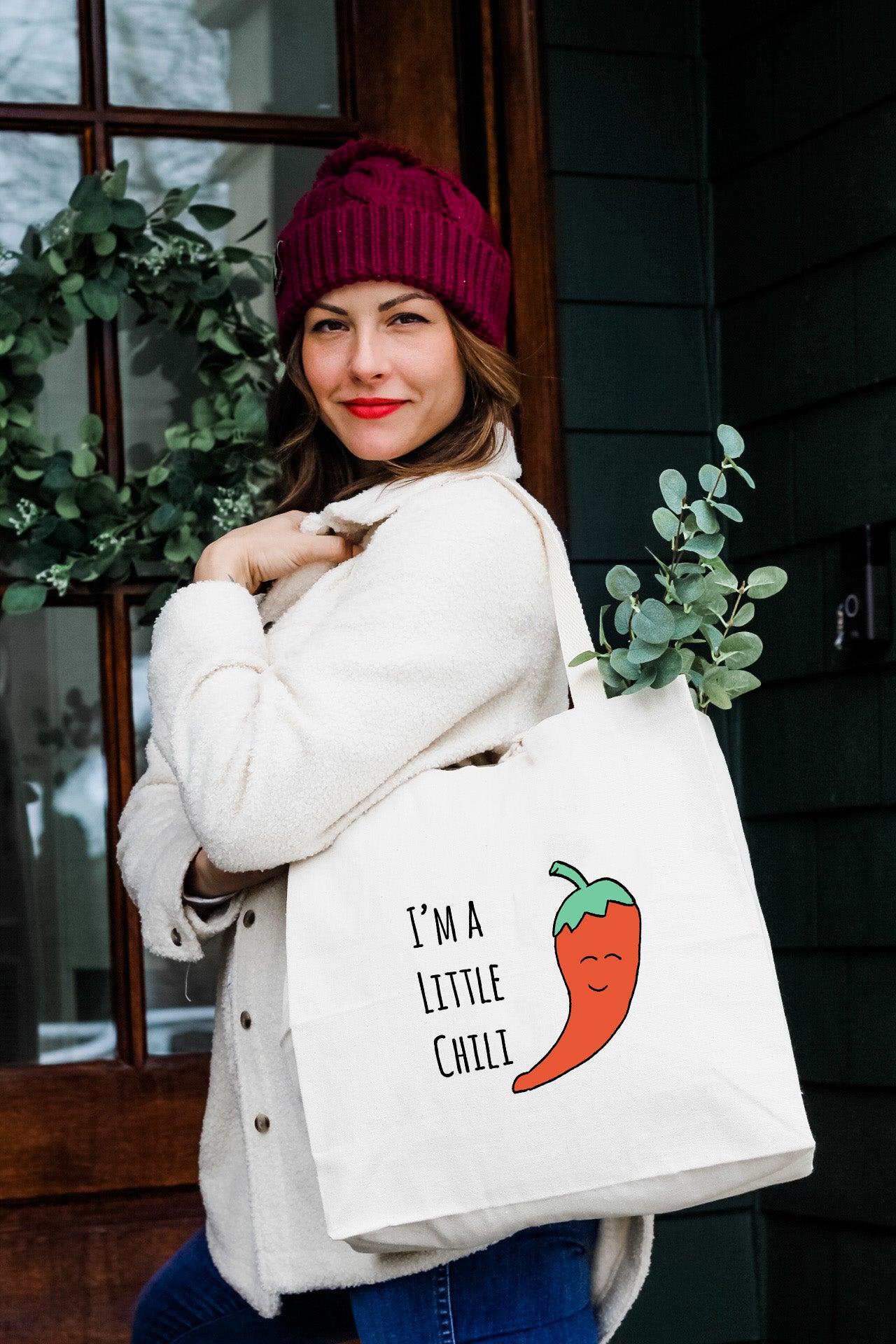 a woman carrying a bag with a chili on it