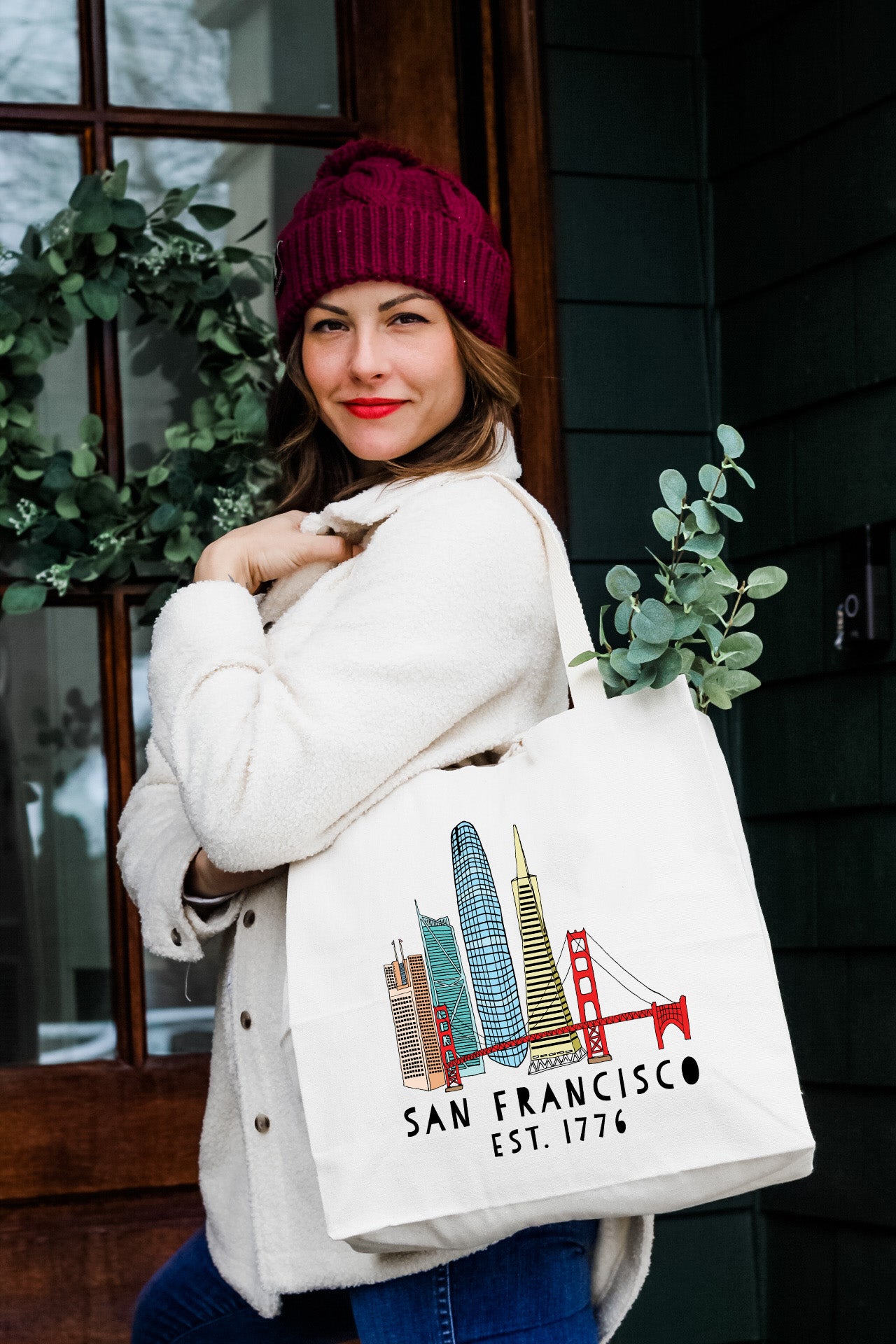 a woman is carrying a san francisco bag