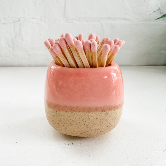 a pink and brown cup with toothpicks sticking out of it