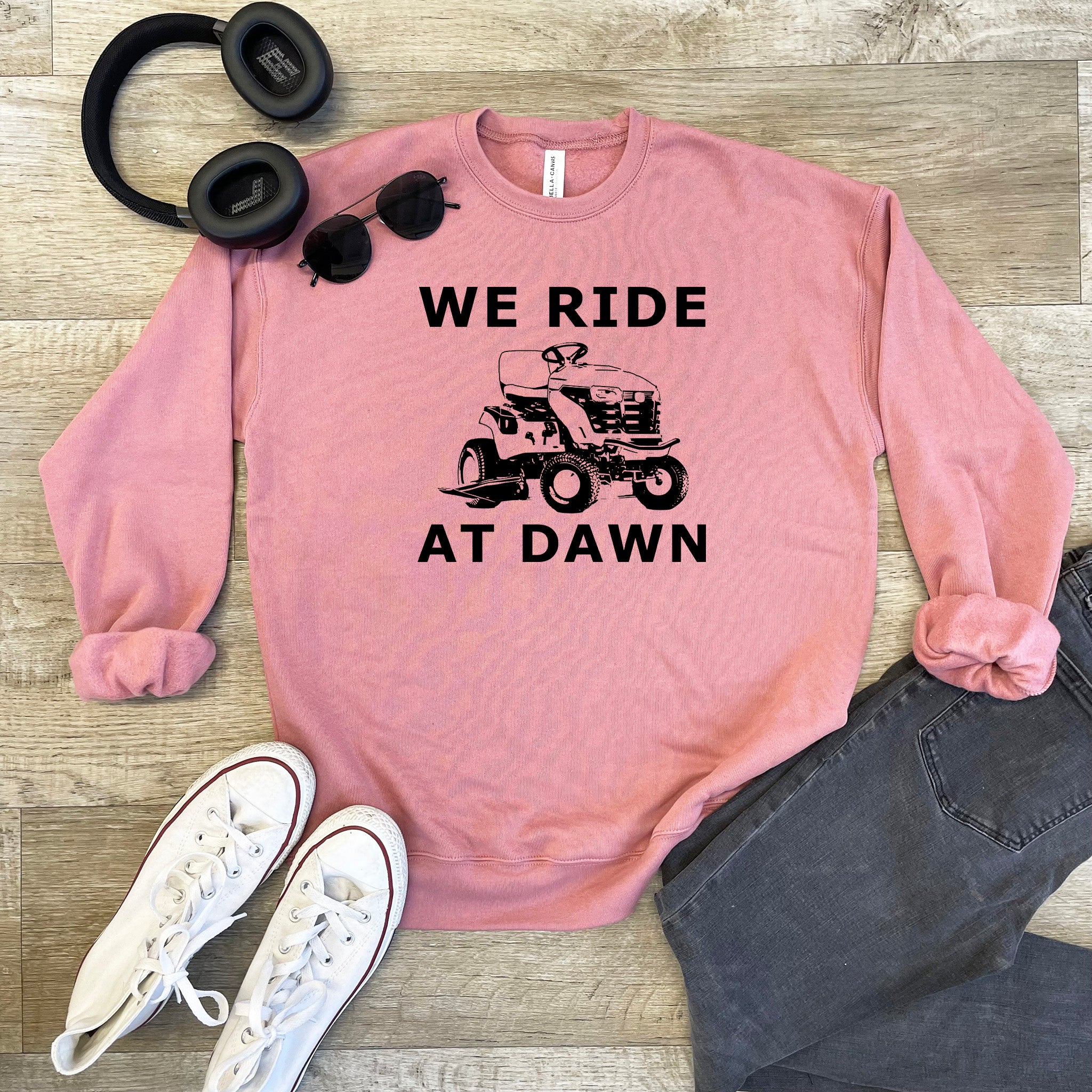 a pink sweatshirt with the words we ride at dawn on it