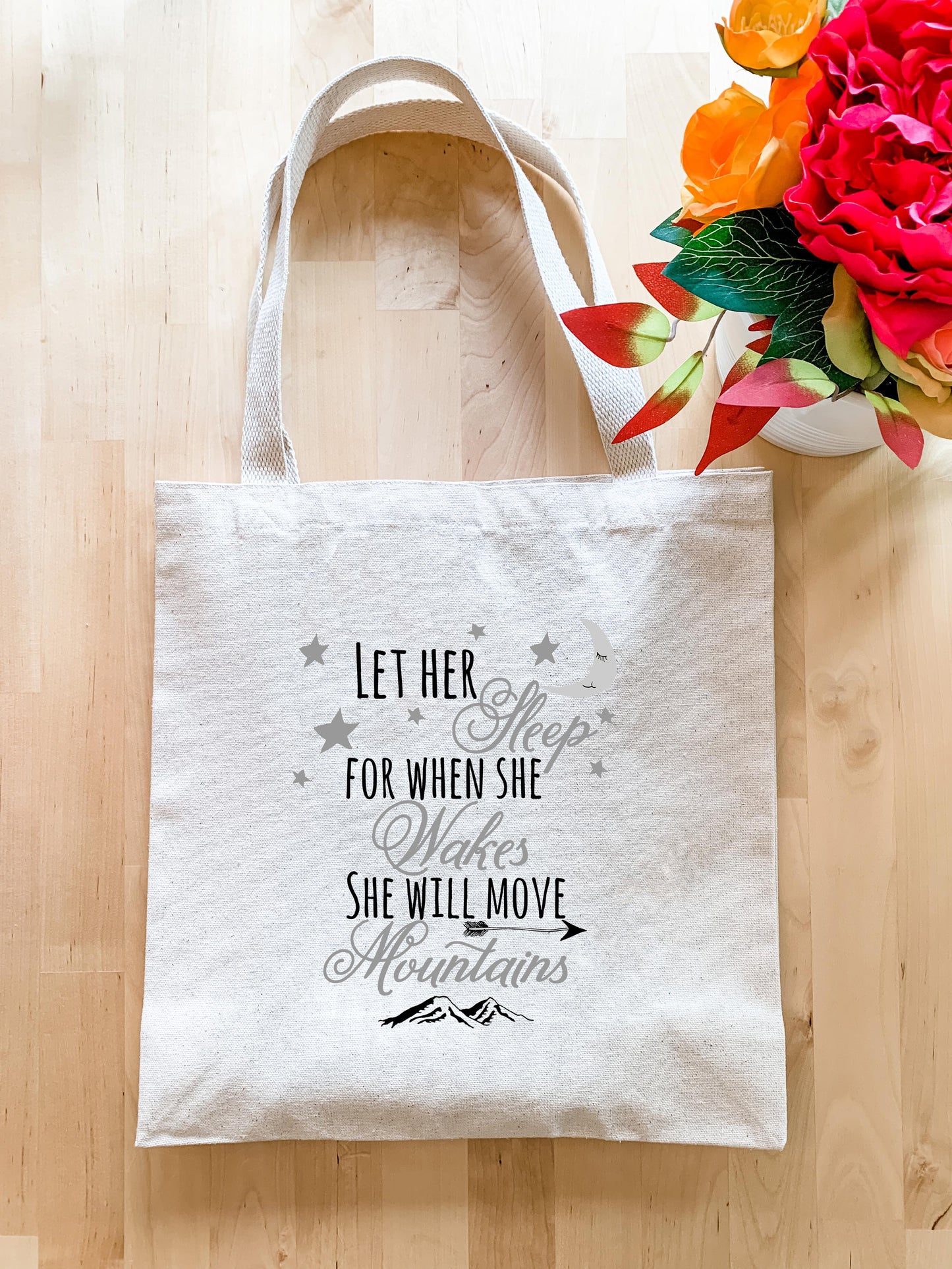 a white tote bag sitting on top of a wooden floor