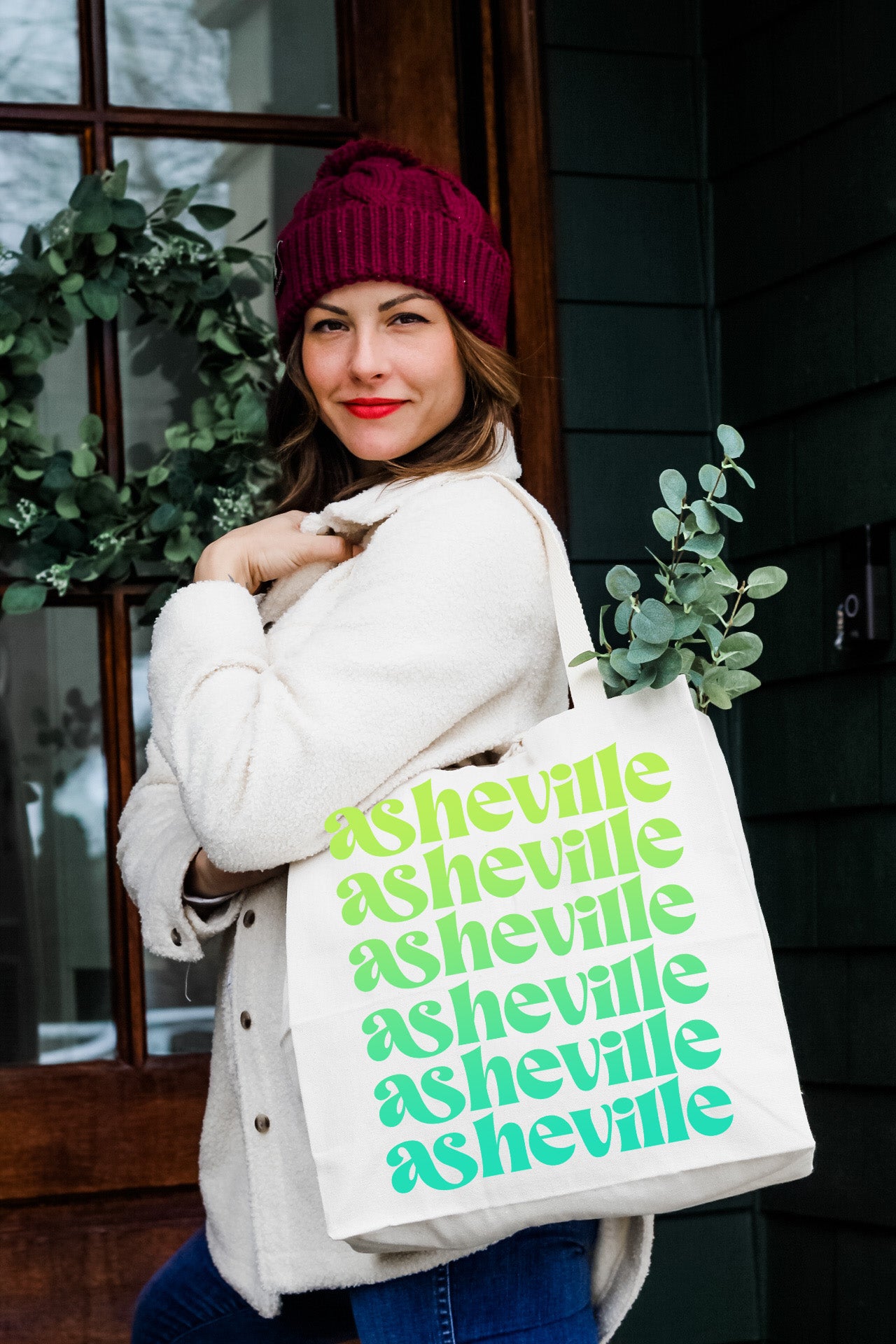 a woman carrying a white bag with green lettering