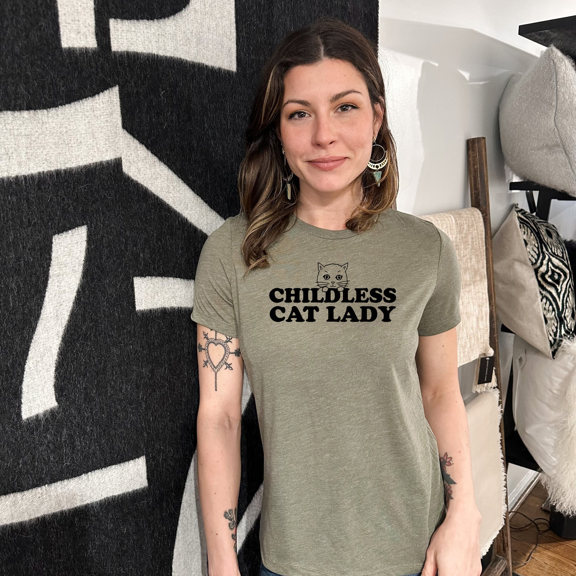 a woman standing in front of a wall with a cat lady t - shirt on