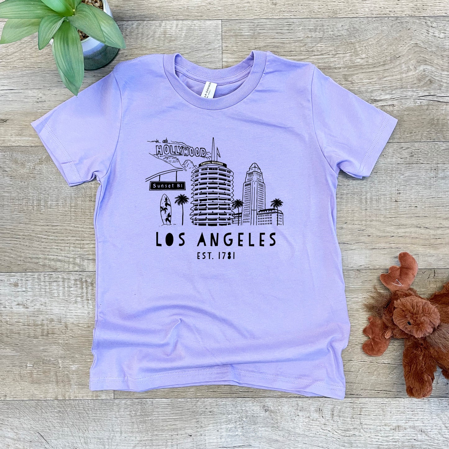 a t - shirt with the los angeles skyline on it next to a teddy bear