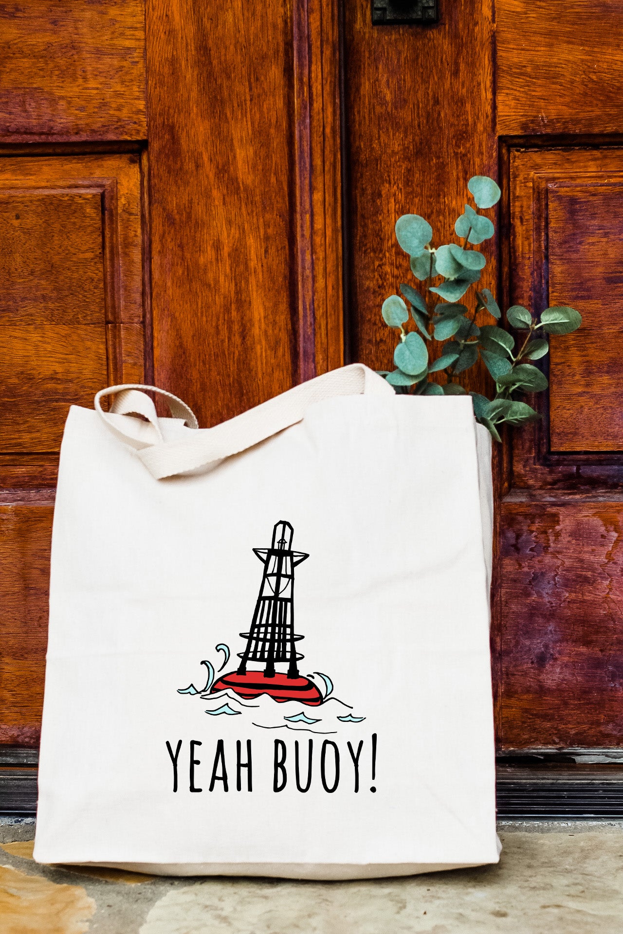 a tote bag sitting in front of a wooden door