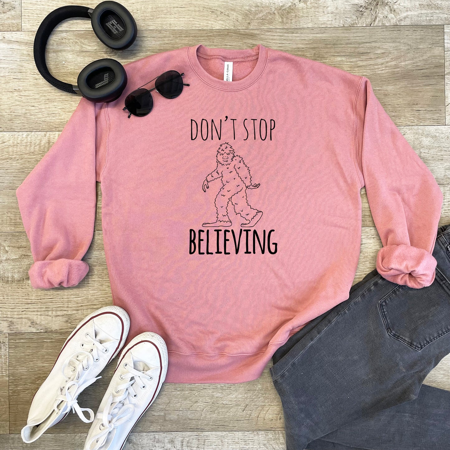 a pink sweatshirt with the words, don't stop believing on it