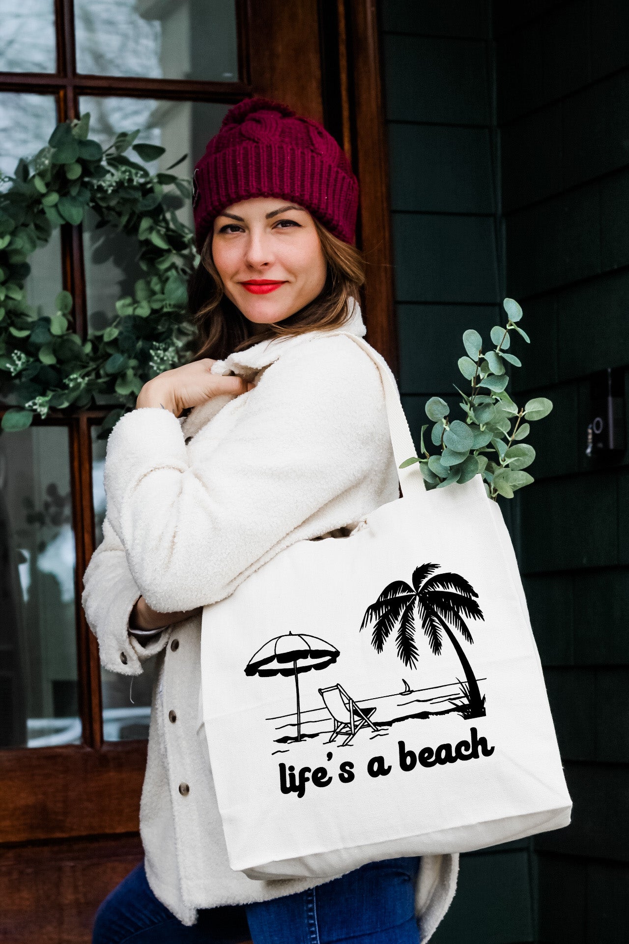 a woman carrying a bag that says life's a beach