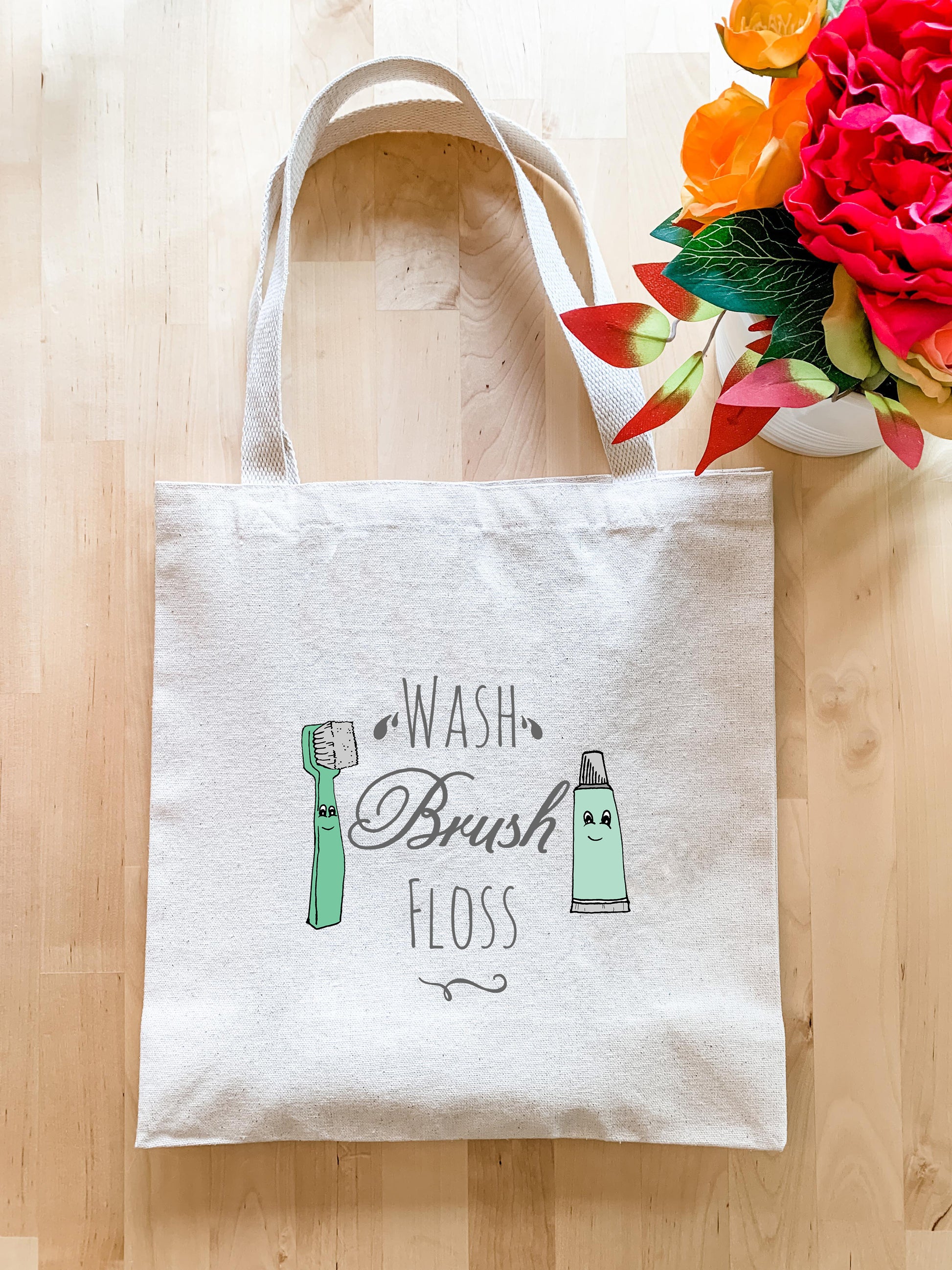 a white tote bag with a brush floss on it