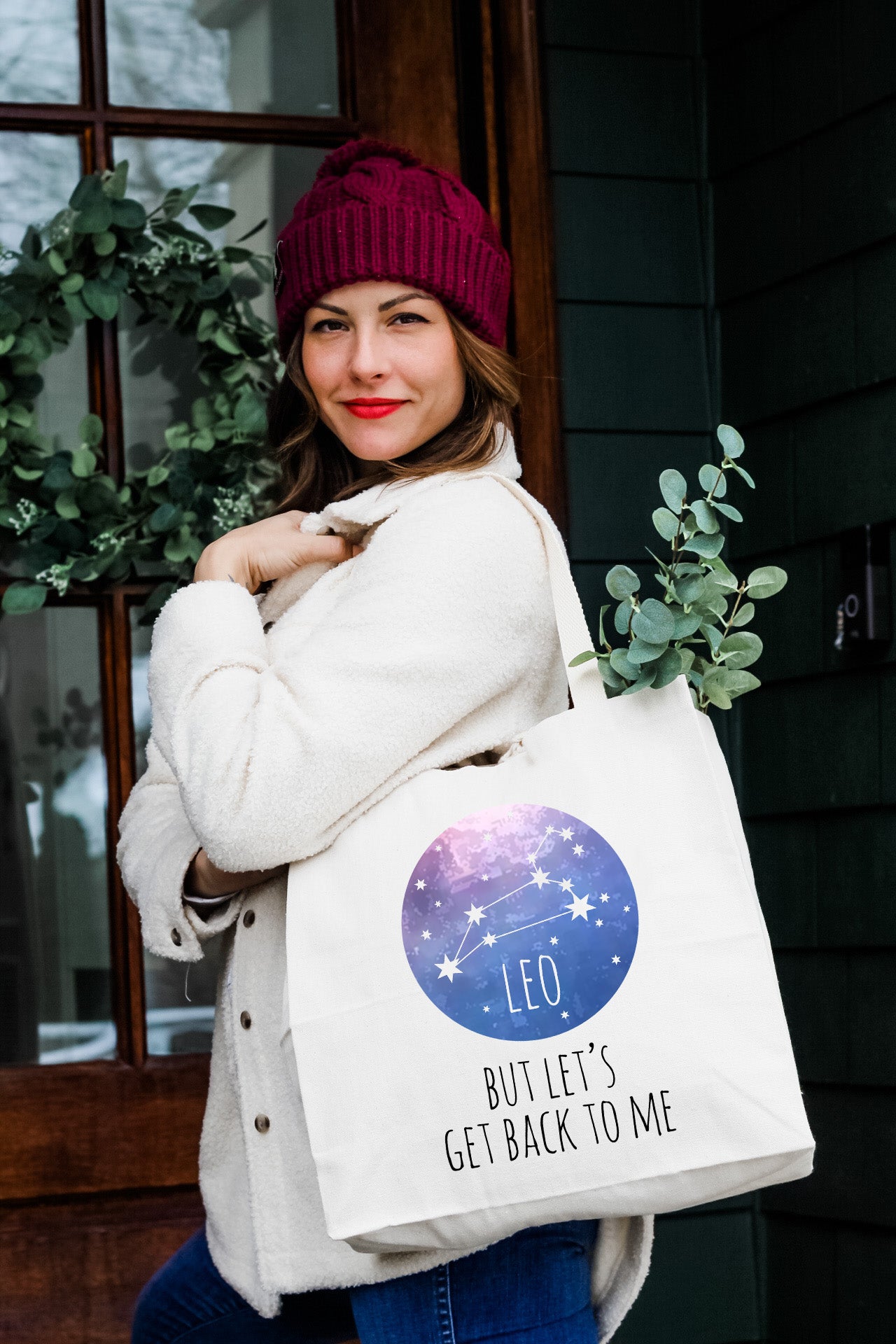 a woman carrying a white bag with the words leo written on it