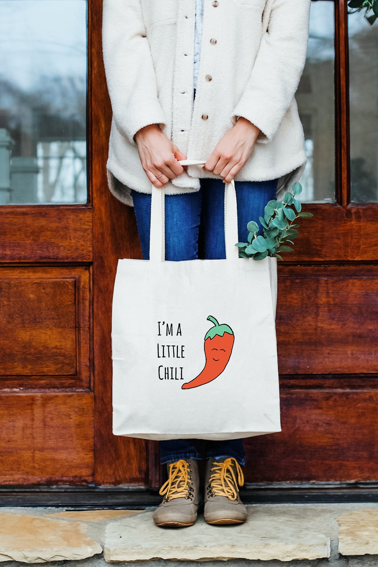 a woman holding a white bag that says i'm a little chili