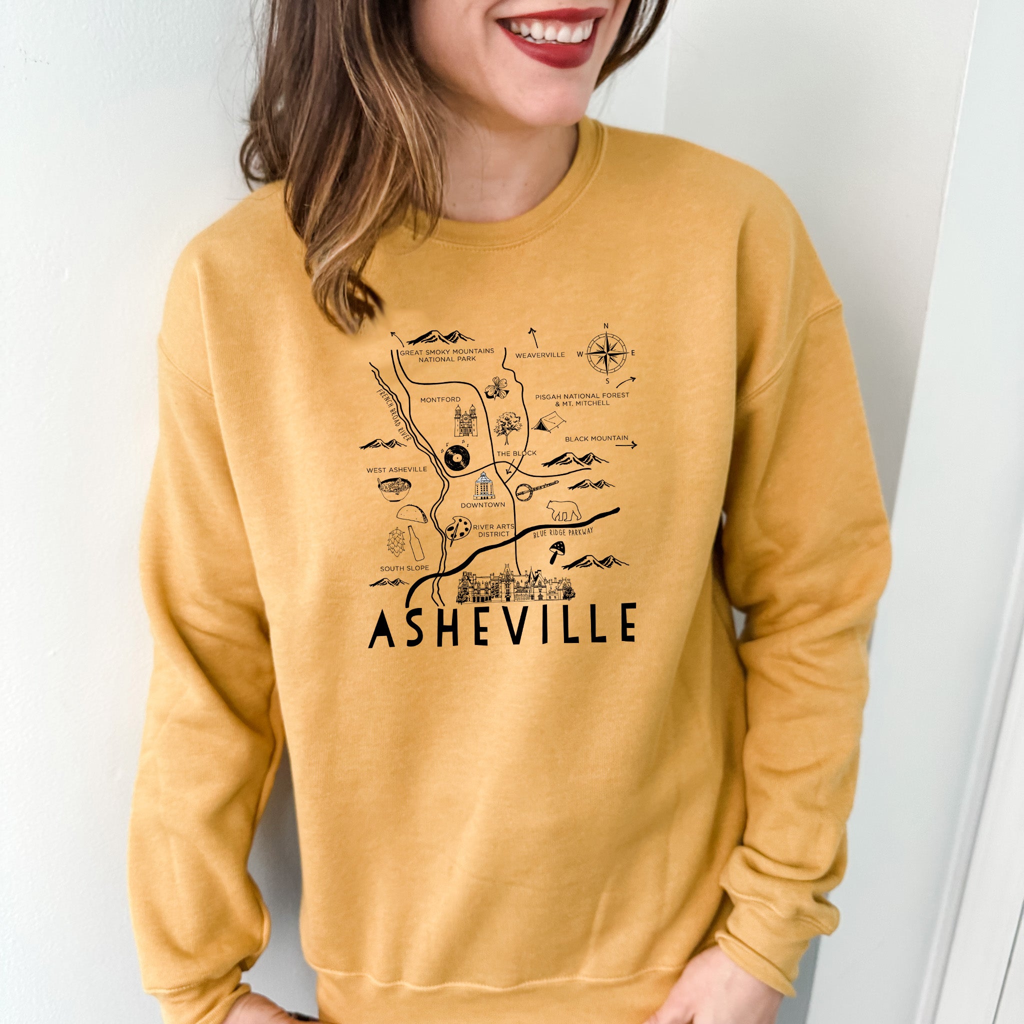 a woman wearing a yellow sweatshirt with a map on it