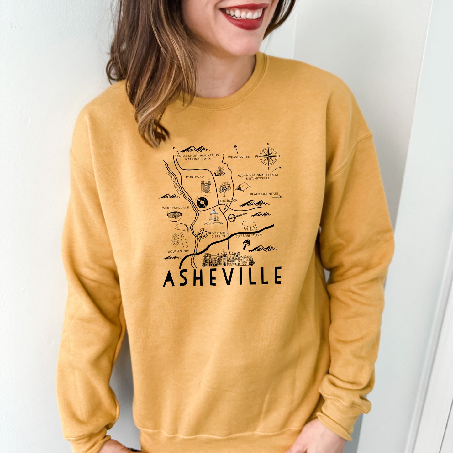 a woman wearing a yellow sweatshirt with a map on it