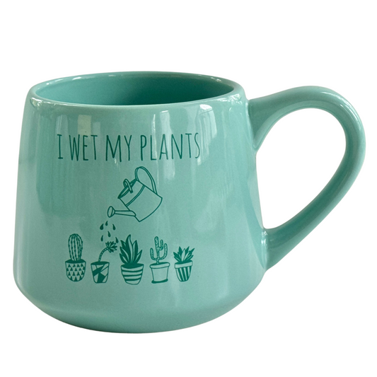 a green mug with a drawing of plants on it