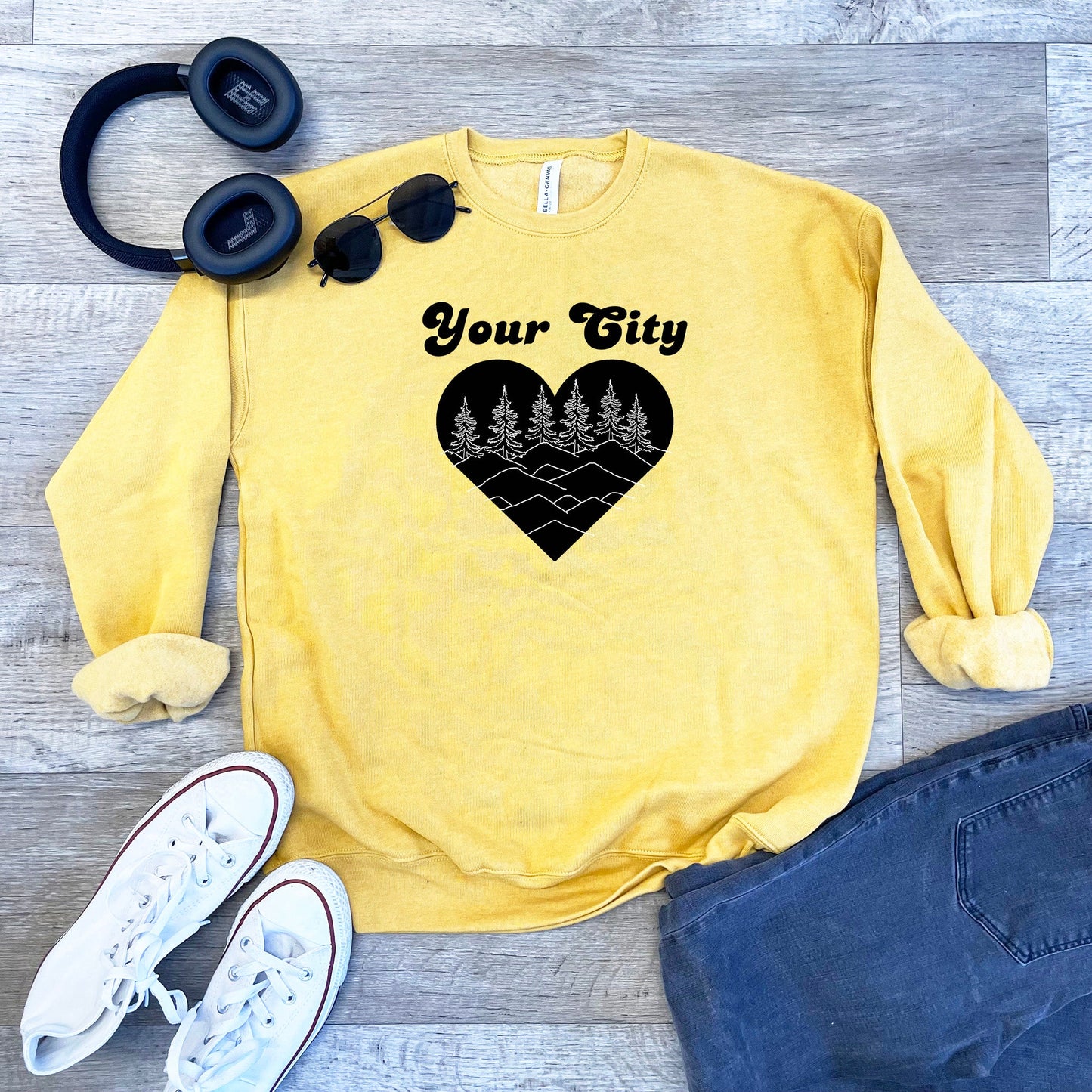 a yellow sweater with a heart and trees on it