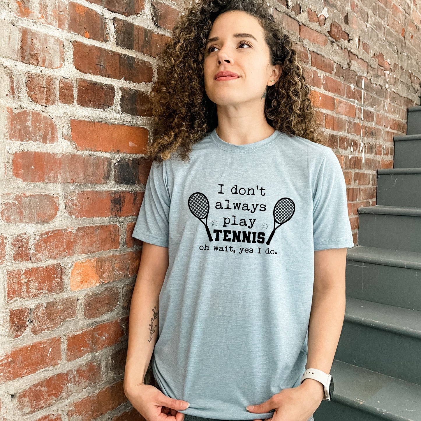 a woman standing next to a brick wall