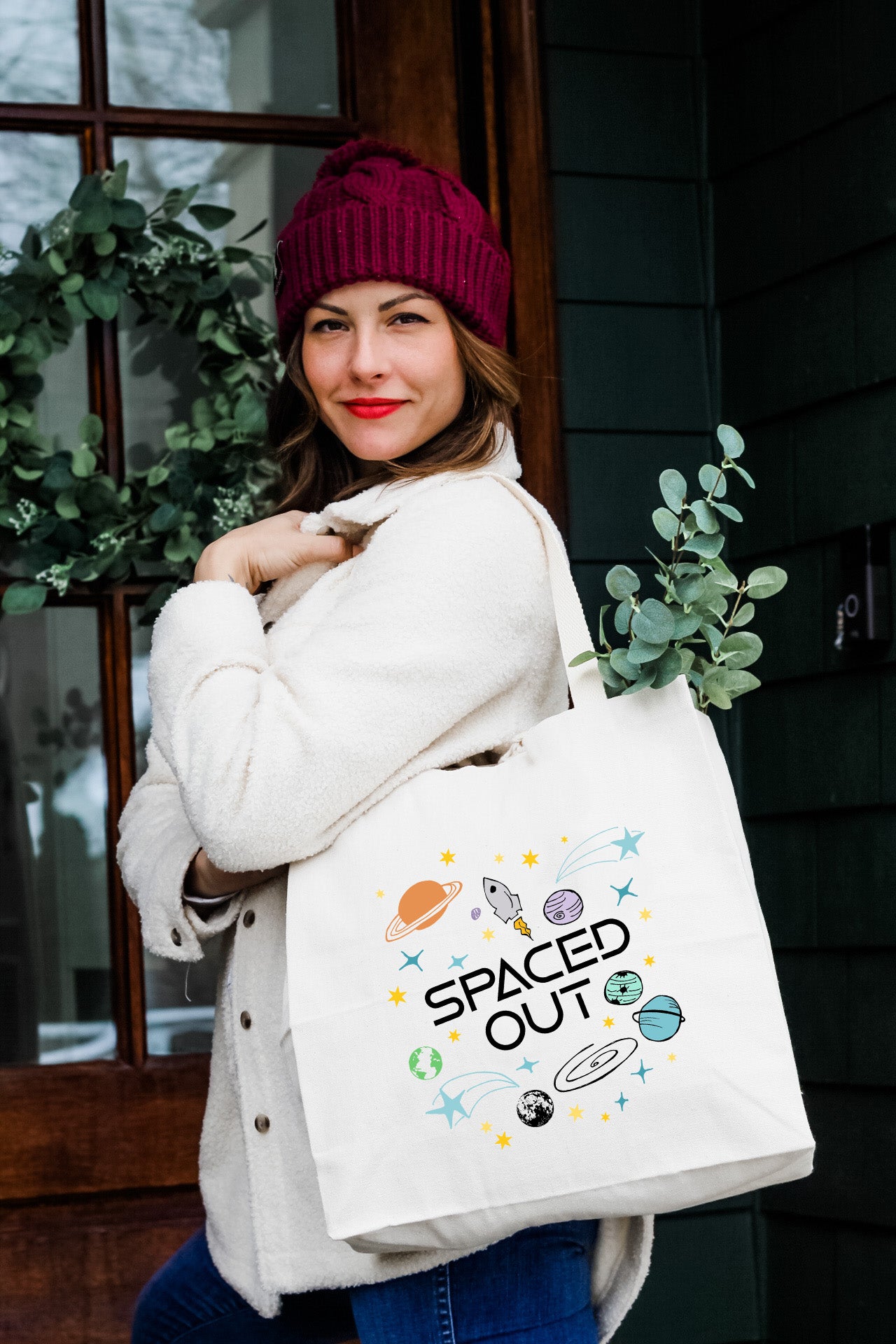 a woman carrying a white bag that says spaced out