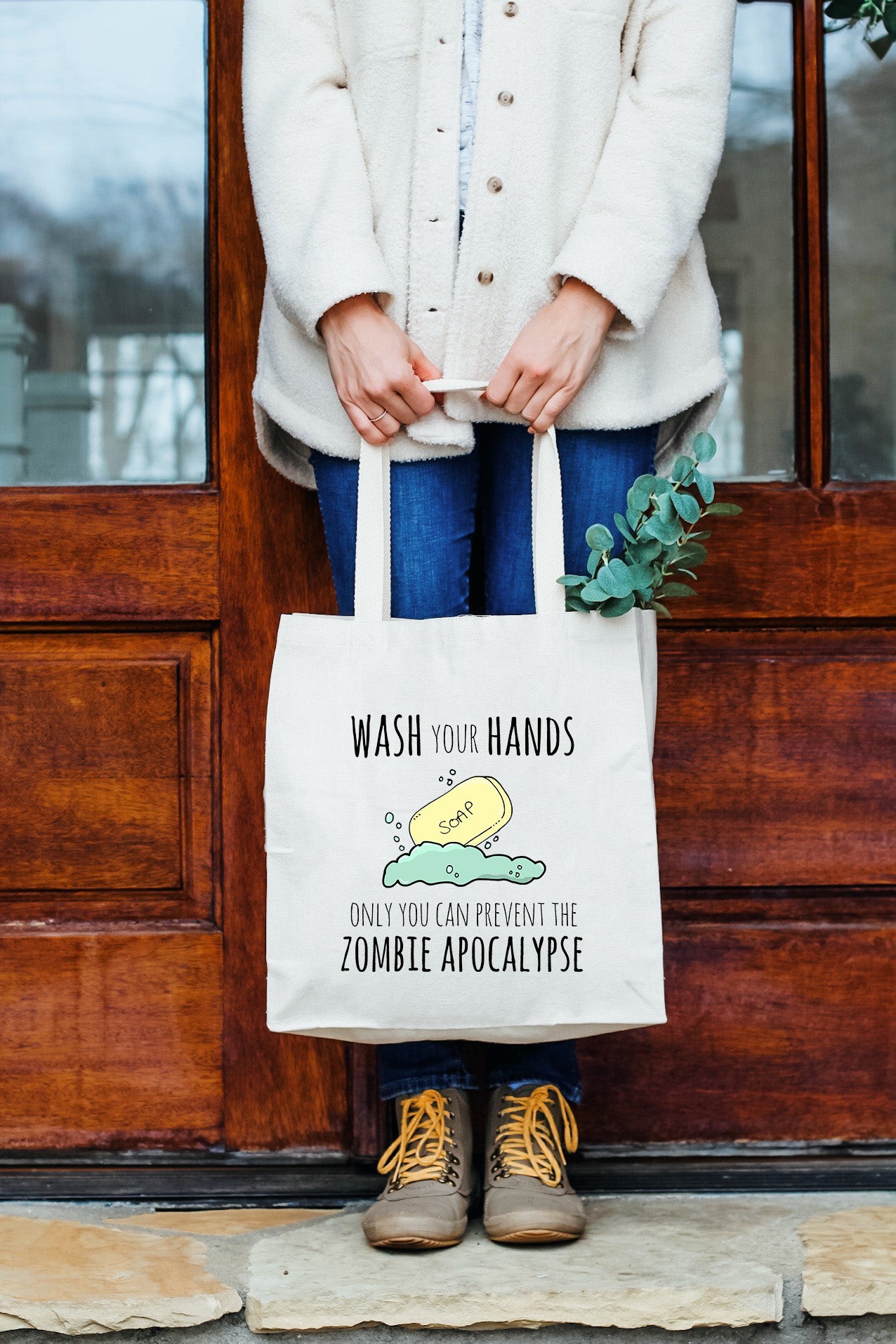 a woman holding a white bag that says wash your hands, don't you