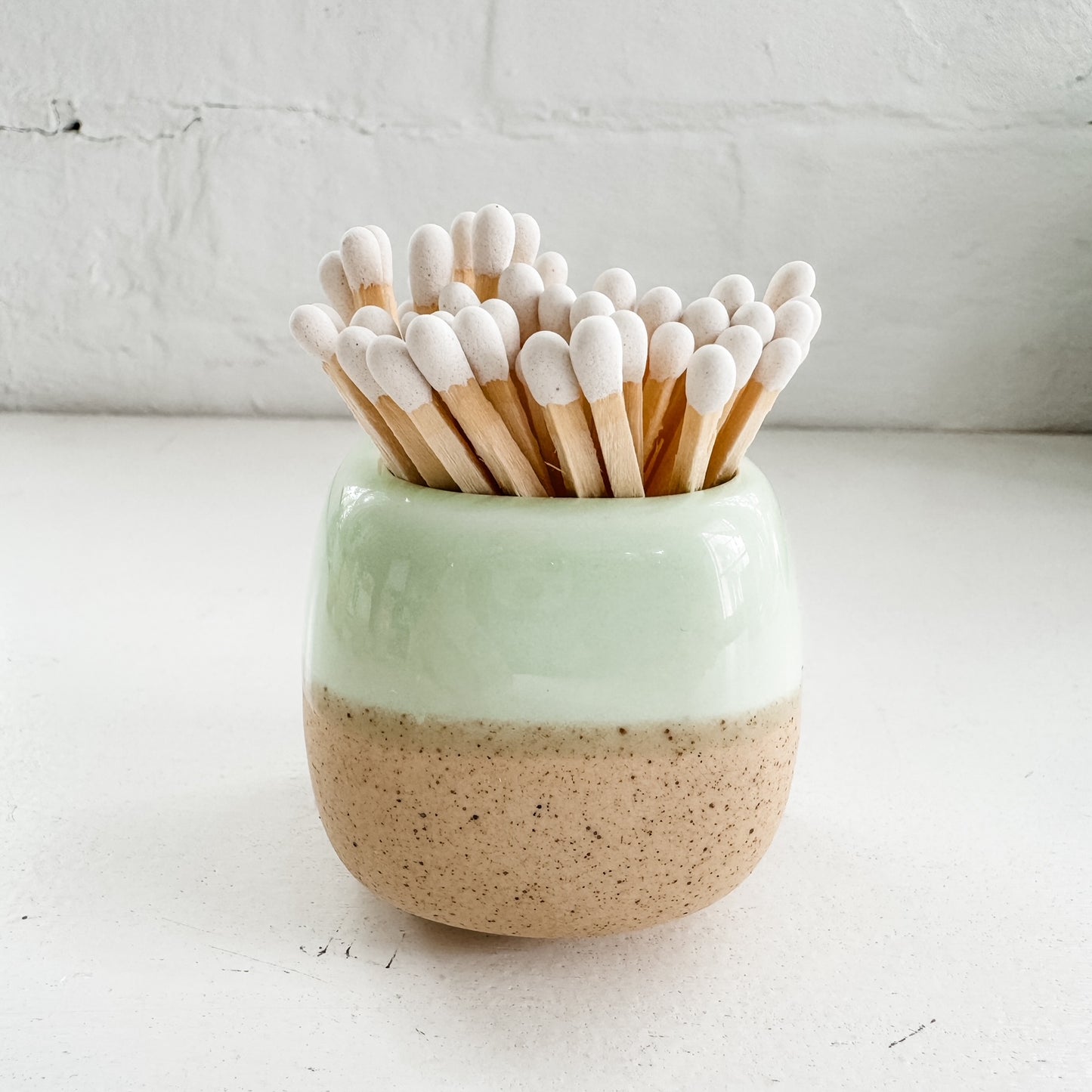 a ceramic cup with toothpicks sticking out of it