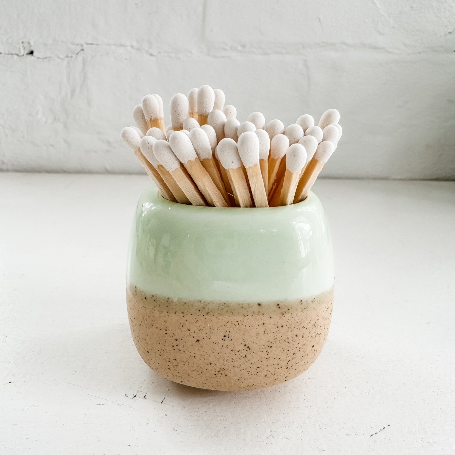 a ceramic cup with toothpicks sticking out of it